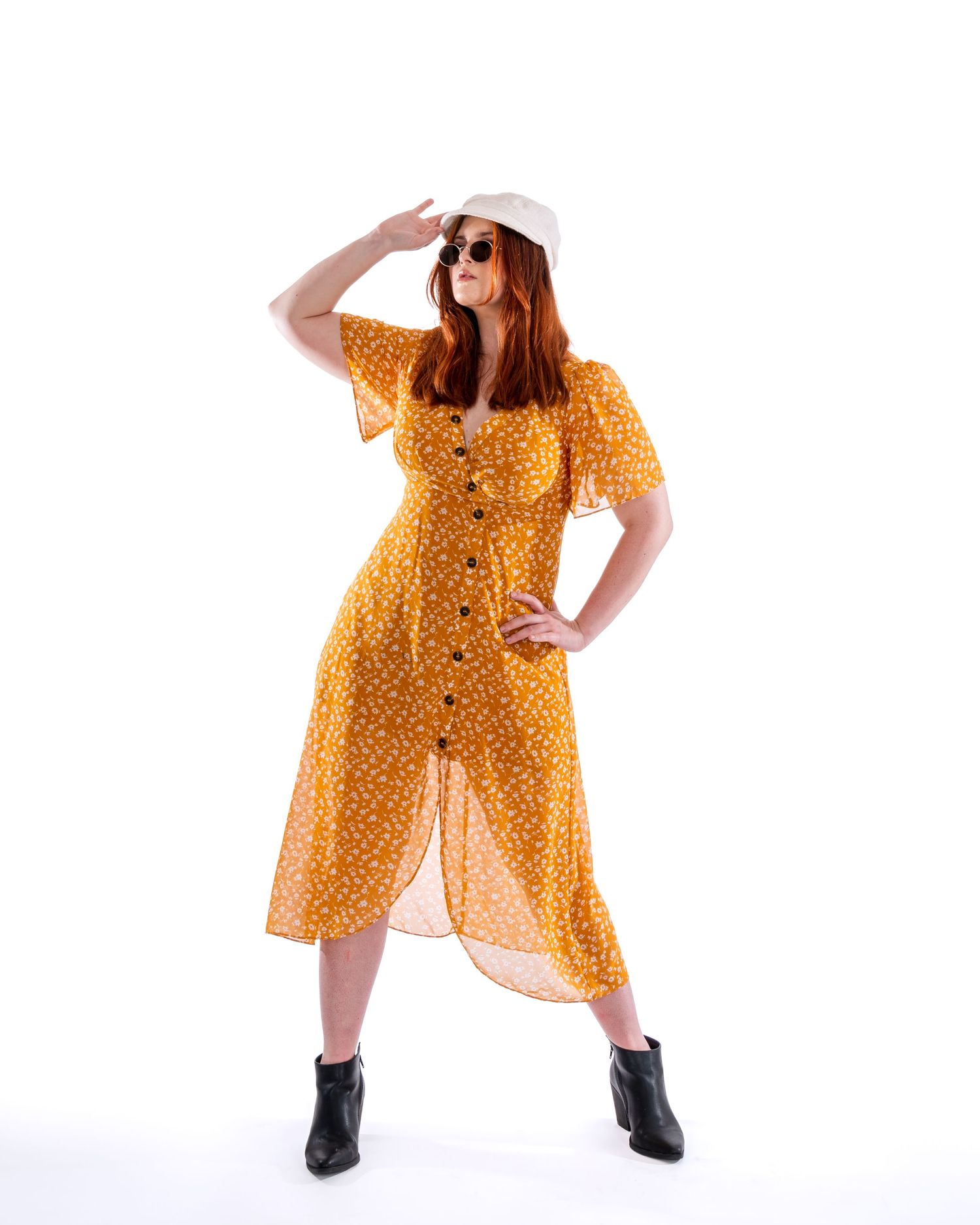 Dynamic fashion poses in a yellow printed dress against a minimalist white backdrop.