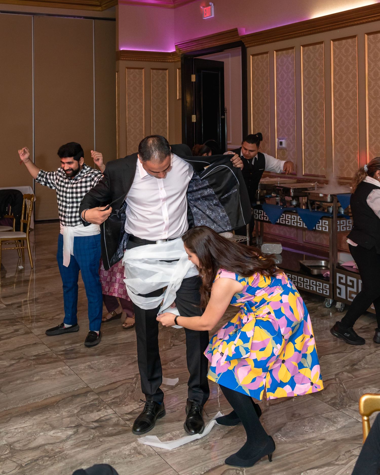 Party guests dancing and having fun at an event with hardwood floors.