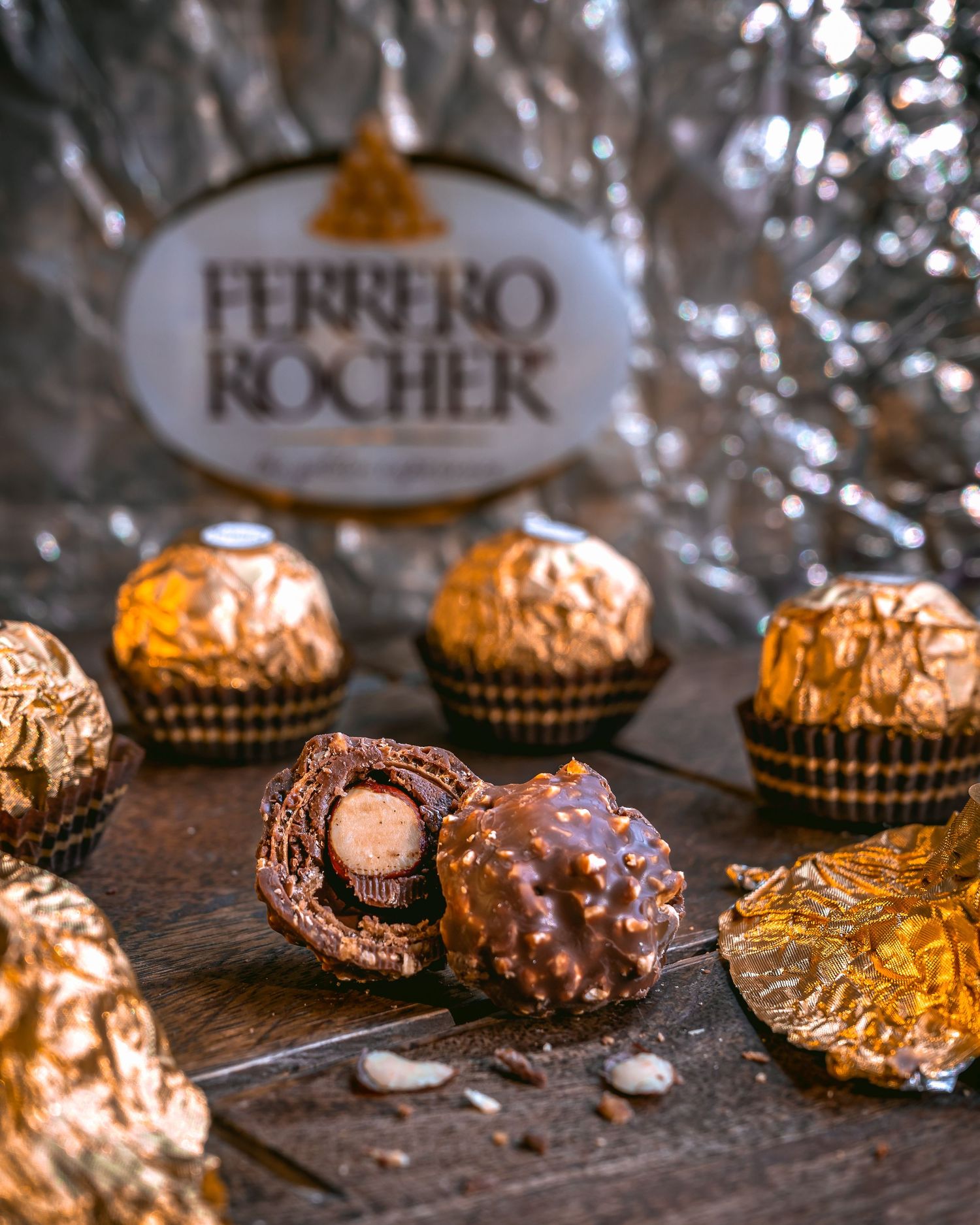 Ferrero Rocher chocolates arranged with golden wrappers on a reflective surface.