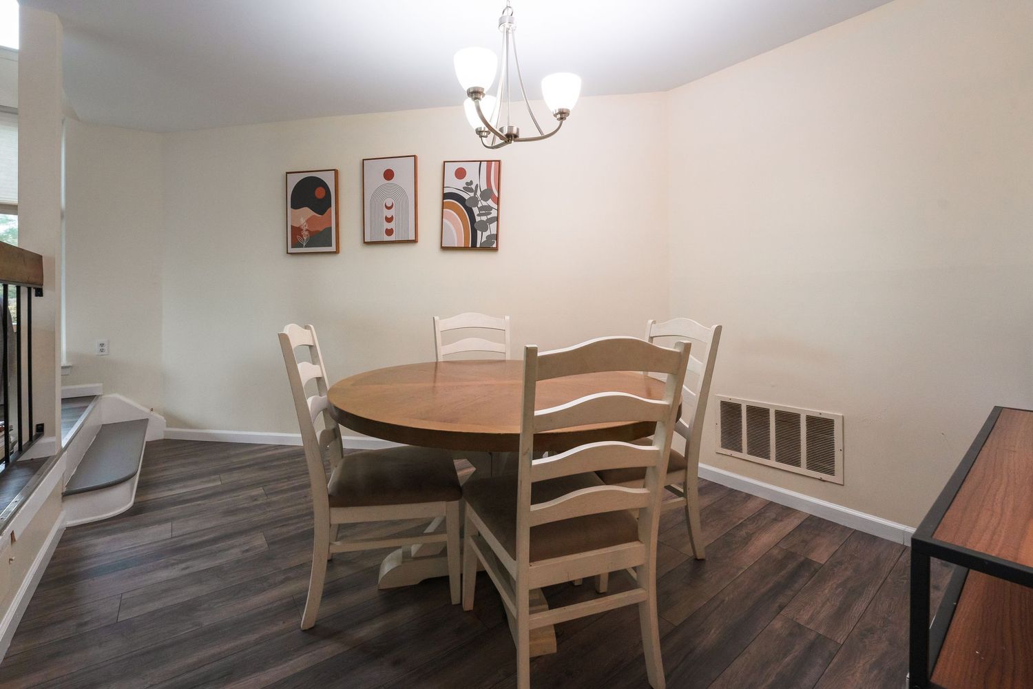 A paneled dining room with beige walls features a traditional wooden table, chairs, and antlers mounted on the wall.