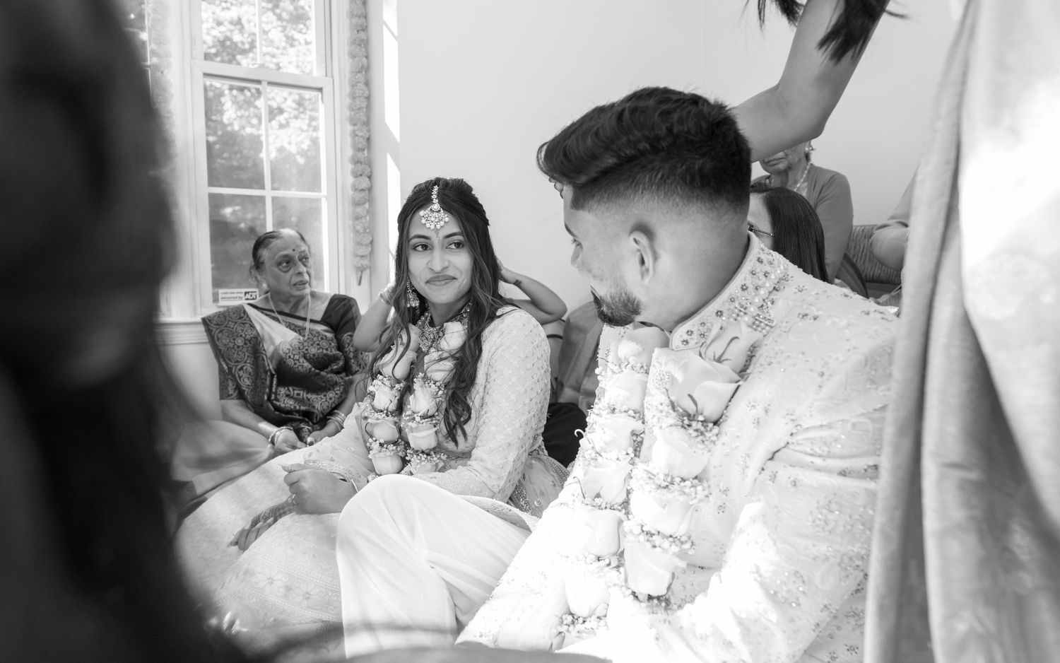 Wedding couple lovingly poses together in elegant white and cream outfits.