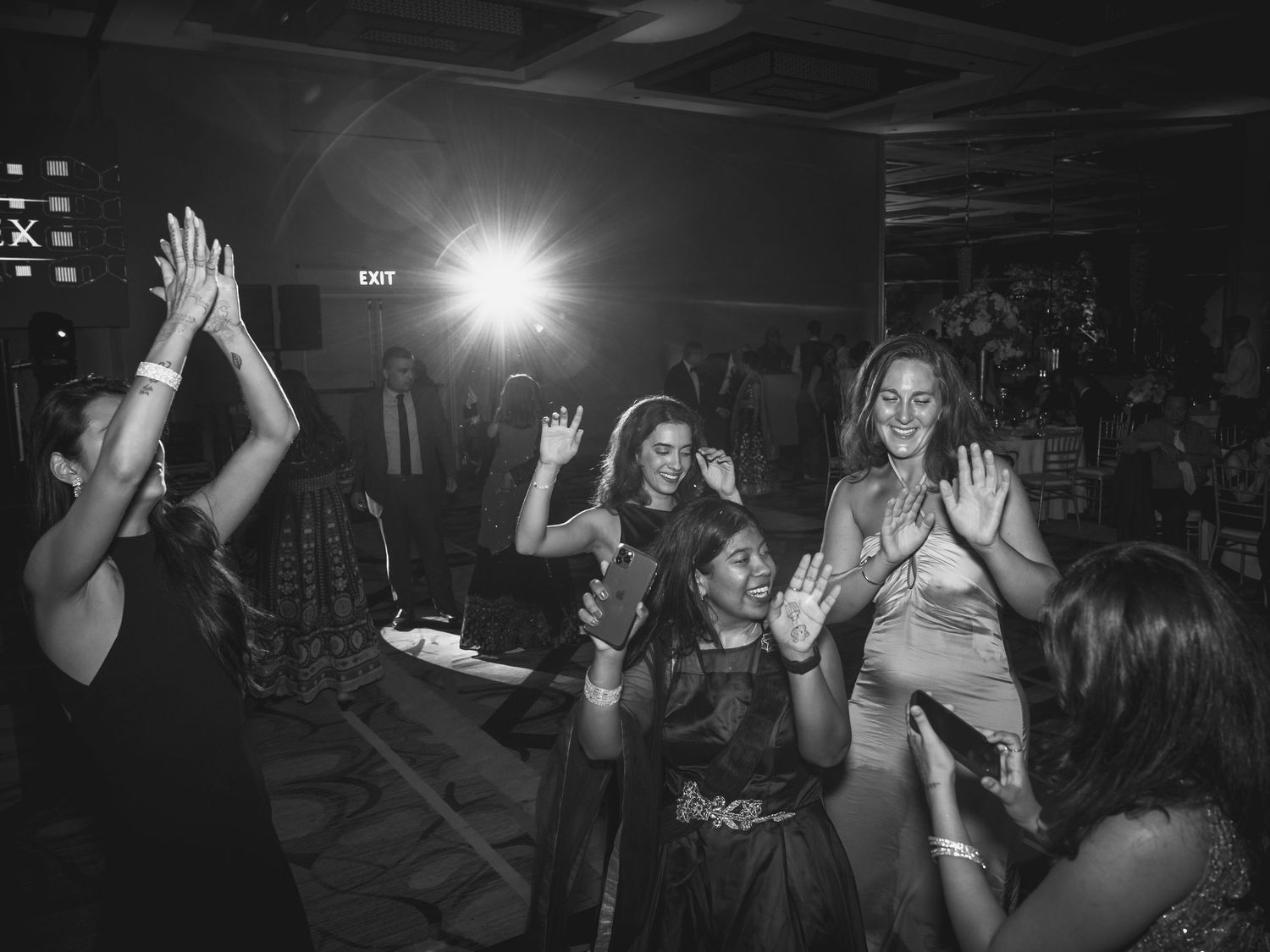 Black and white photo of people dancing and celebrating at a nightclub.