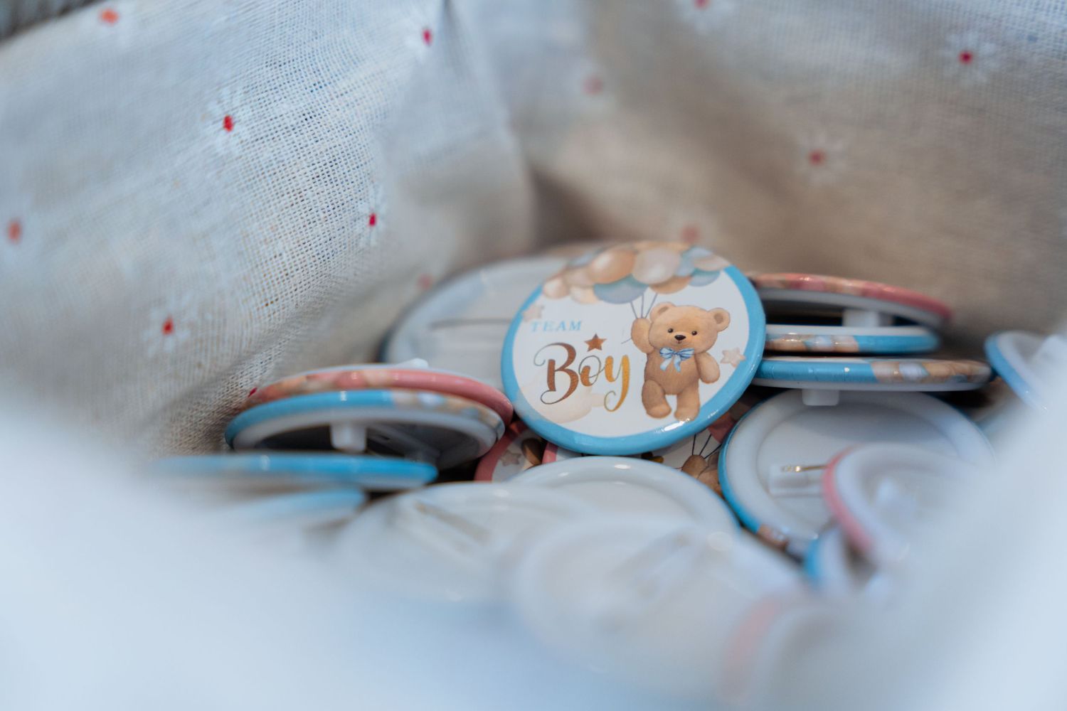 A series of baby-themed items including pacifiers and decorative elements arranged in a soft, pastel-colored setting.