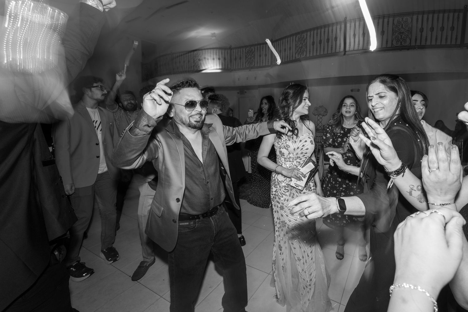 Black and white photos of wedding guests dancing and celebrating on the dance floor.