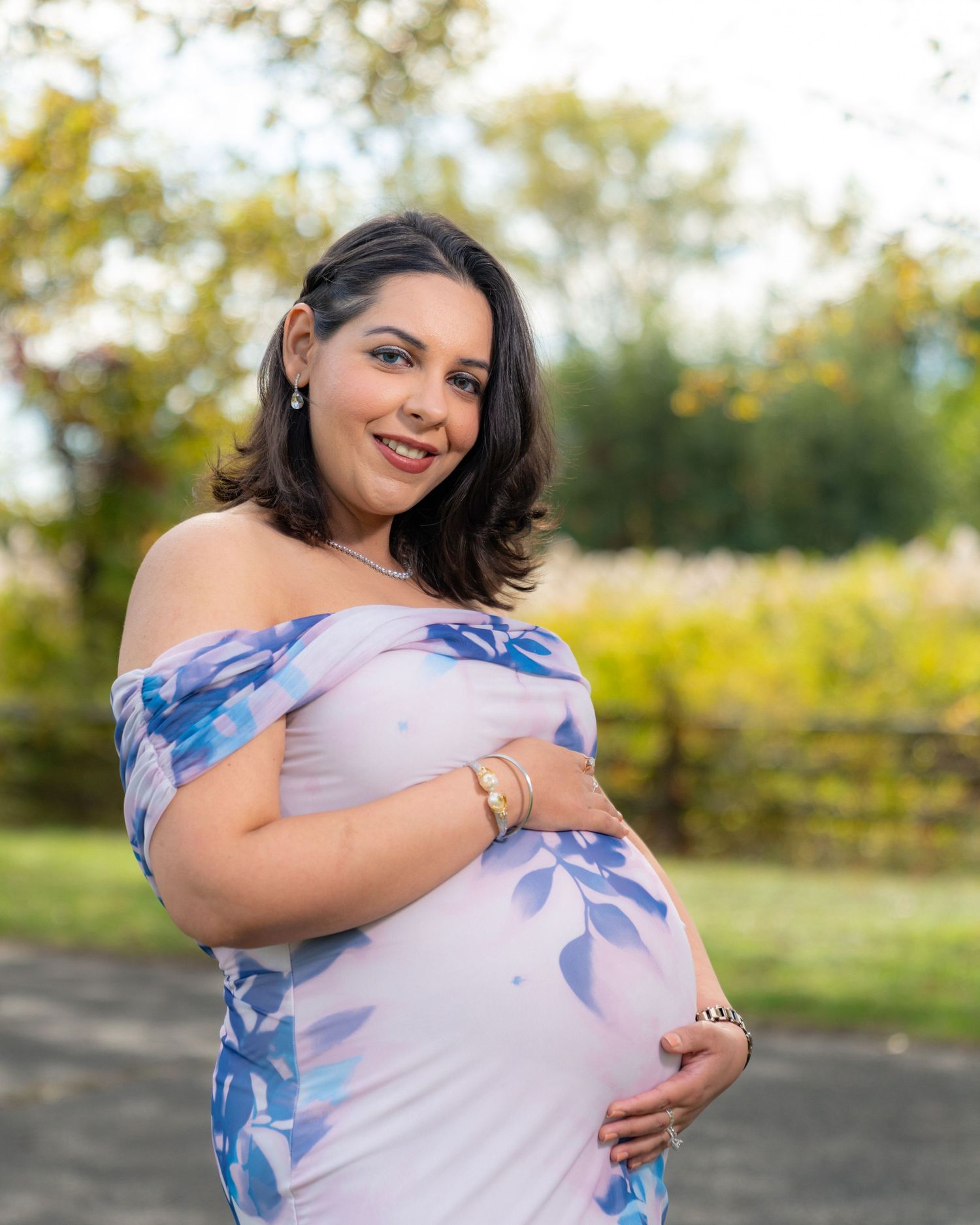 Maternity photos showing tender moments between expectant parents in an outdoor setting.