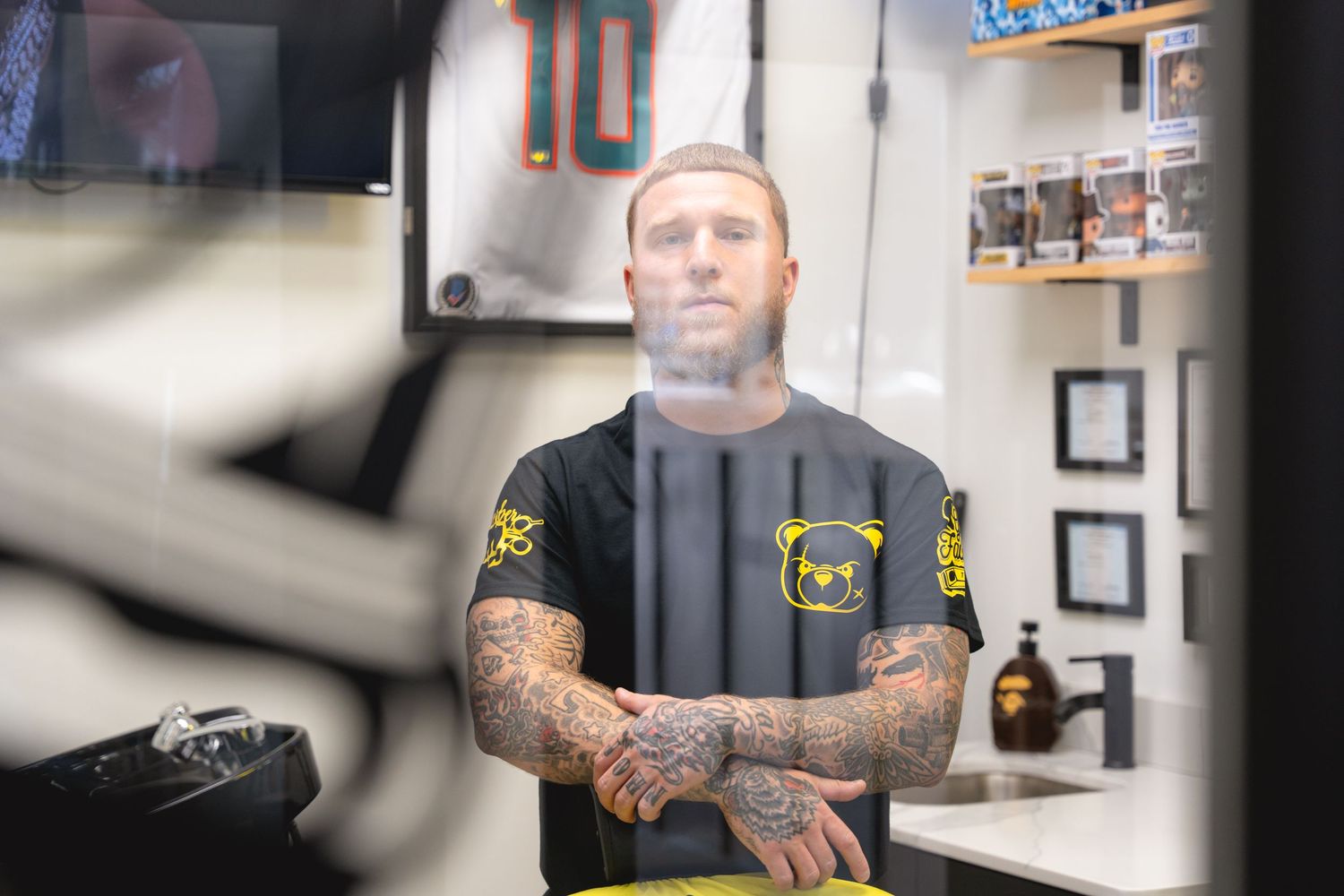 Professional tattoo studio interior with framed artwork and black accents.