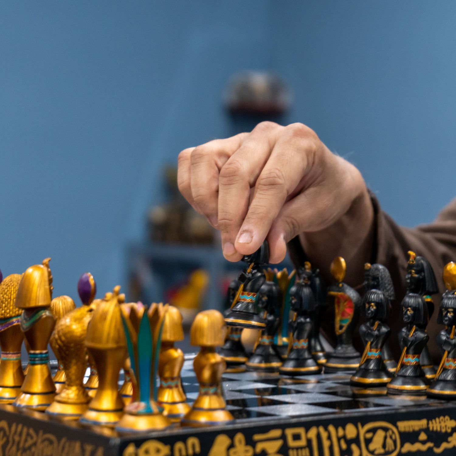 Close-up view of wooden chess pieces lined up on a chess board showing yellow and black pieces in focus.