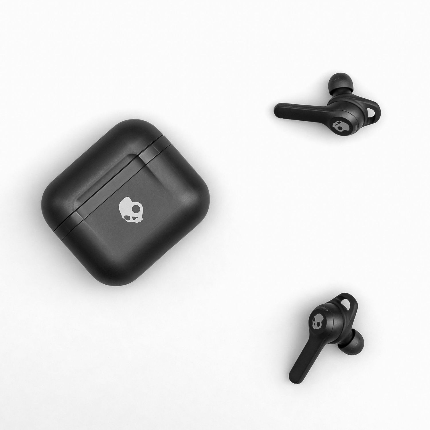 Black wireless earbuds and charging case with skull logo shown against white background.