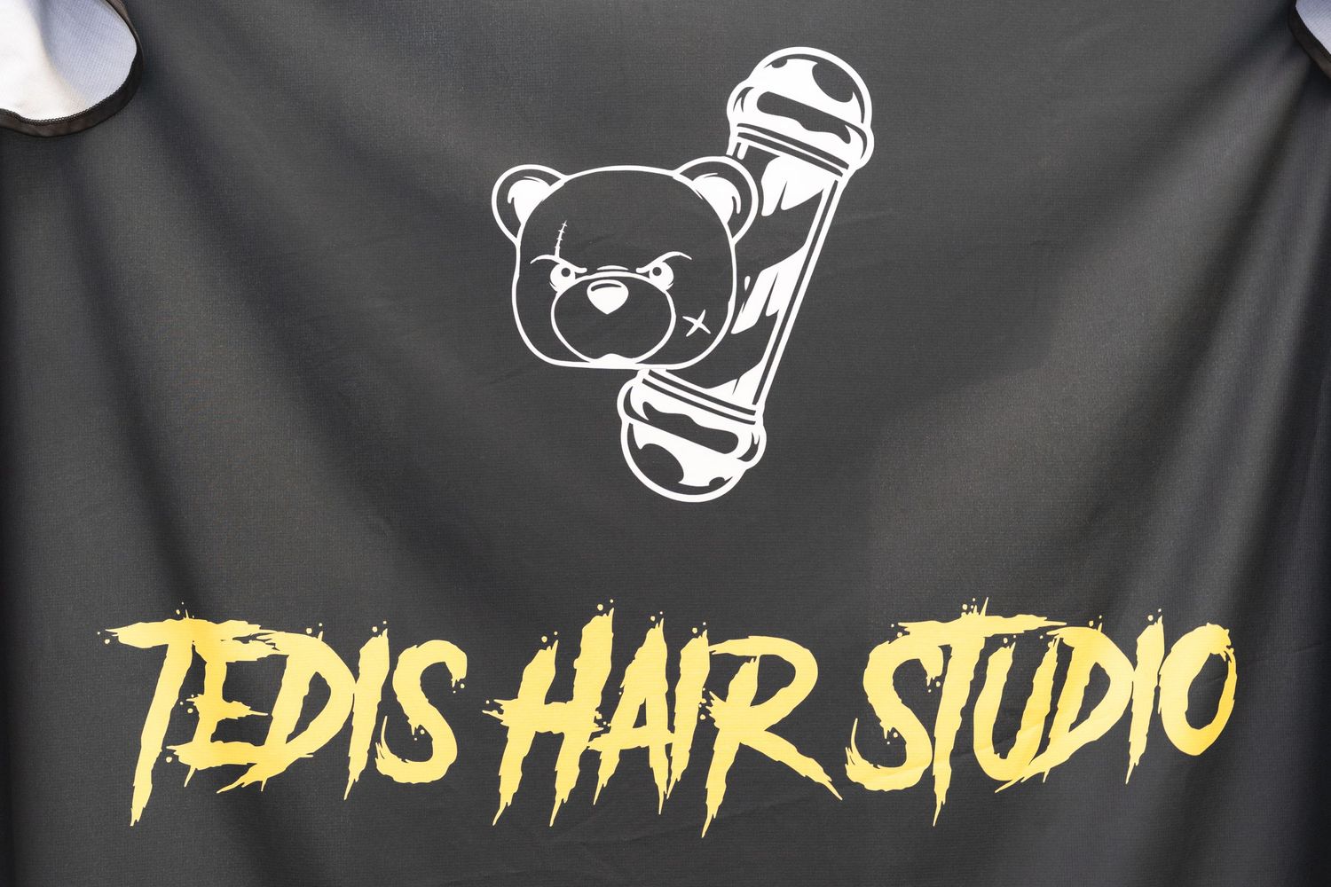 Large banner displaying hair studio branding with cartoon bear mascot graphics.
