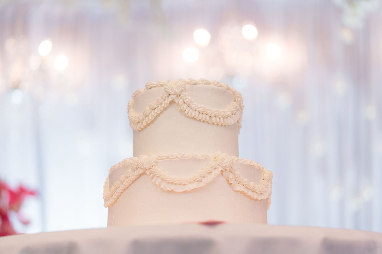 Classic white wedding cake with delicate piped swag details.