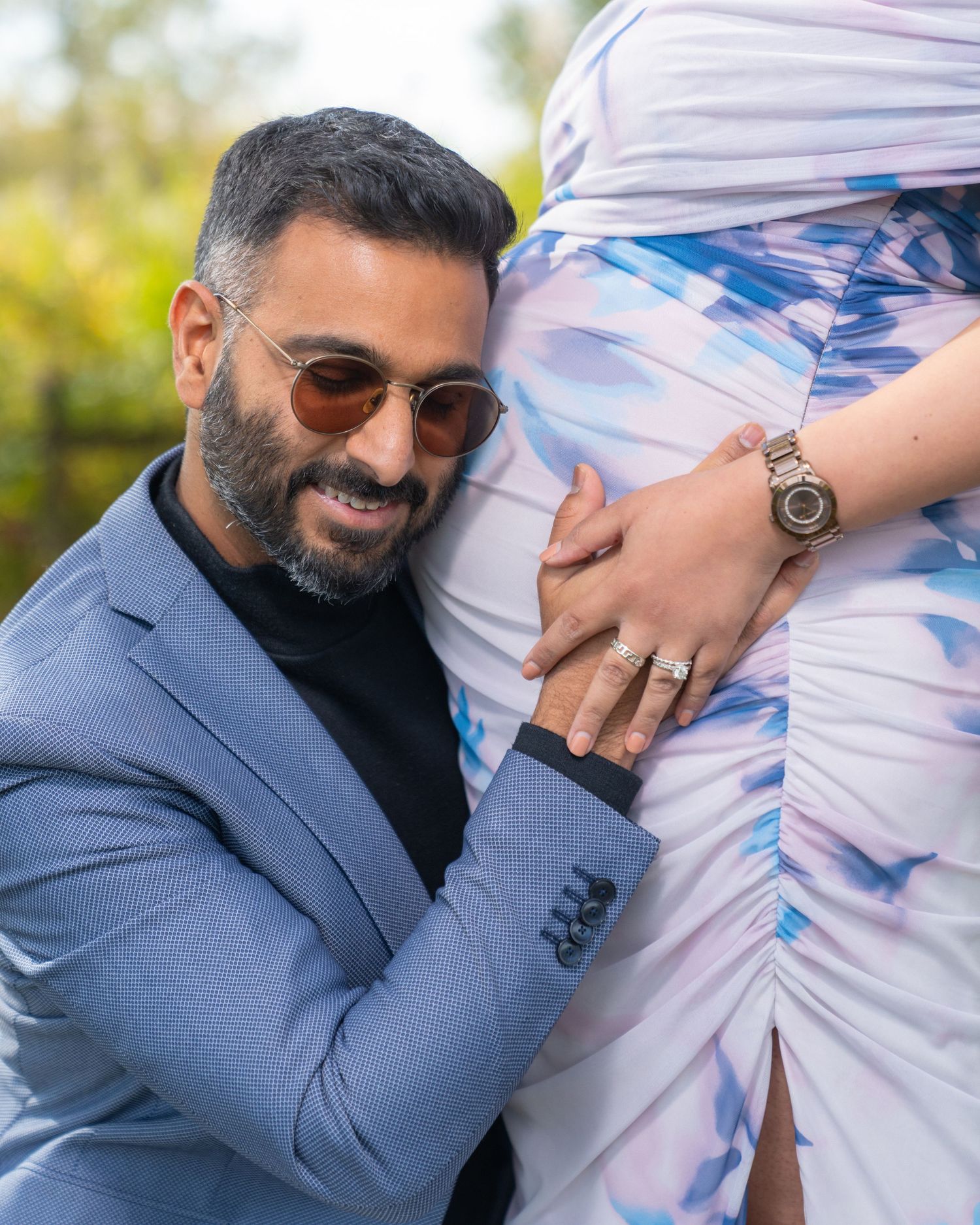 A series of intimate maternity photos showing a couple in a blue suit and flowing dress against a sunlit outdoor backdrop.