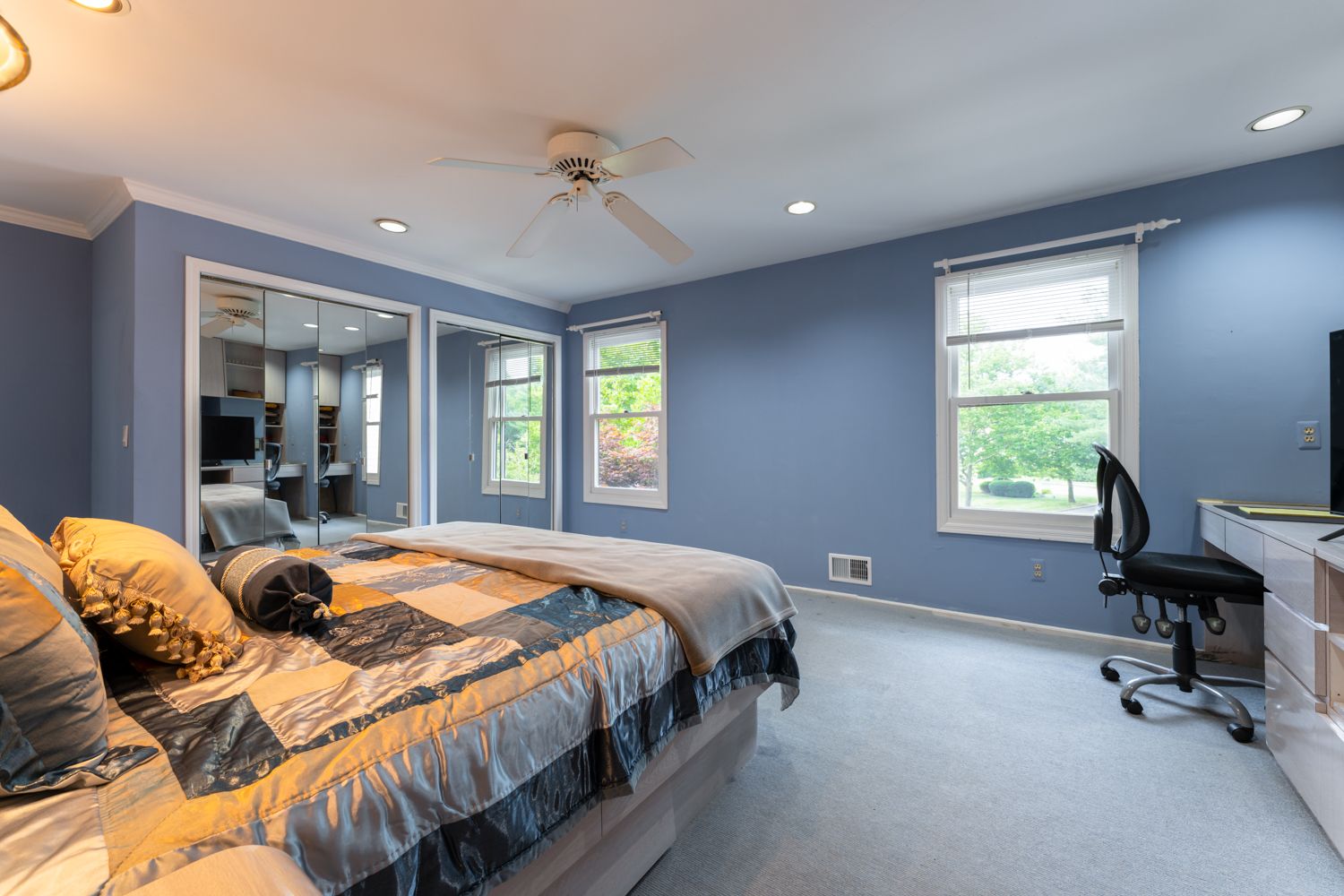Four identical photos showing a modern bedroom with blue walls, white trim, and a queen bed with tan bedding and windows.