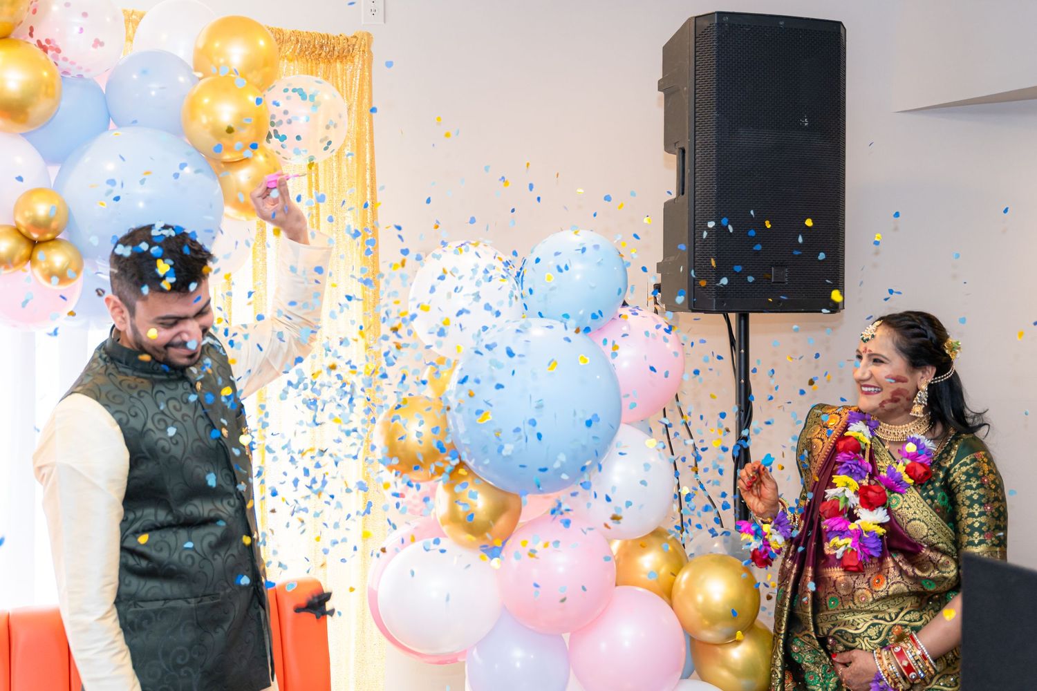 Colorful balloon arch with pink, blue and gold decorations at a festive celebration.