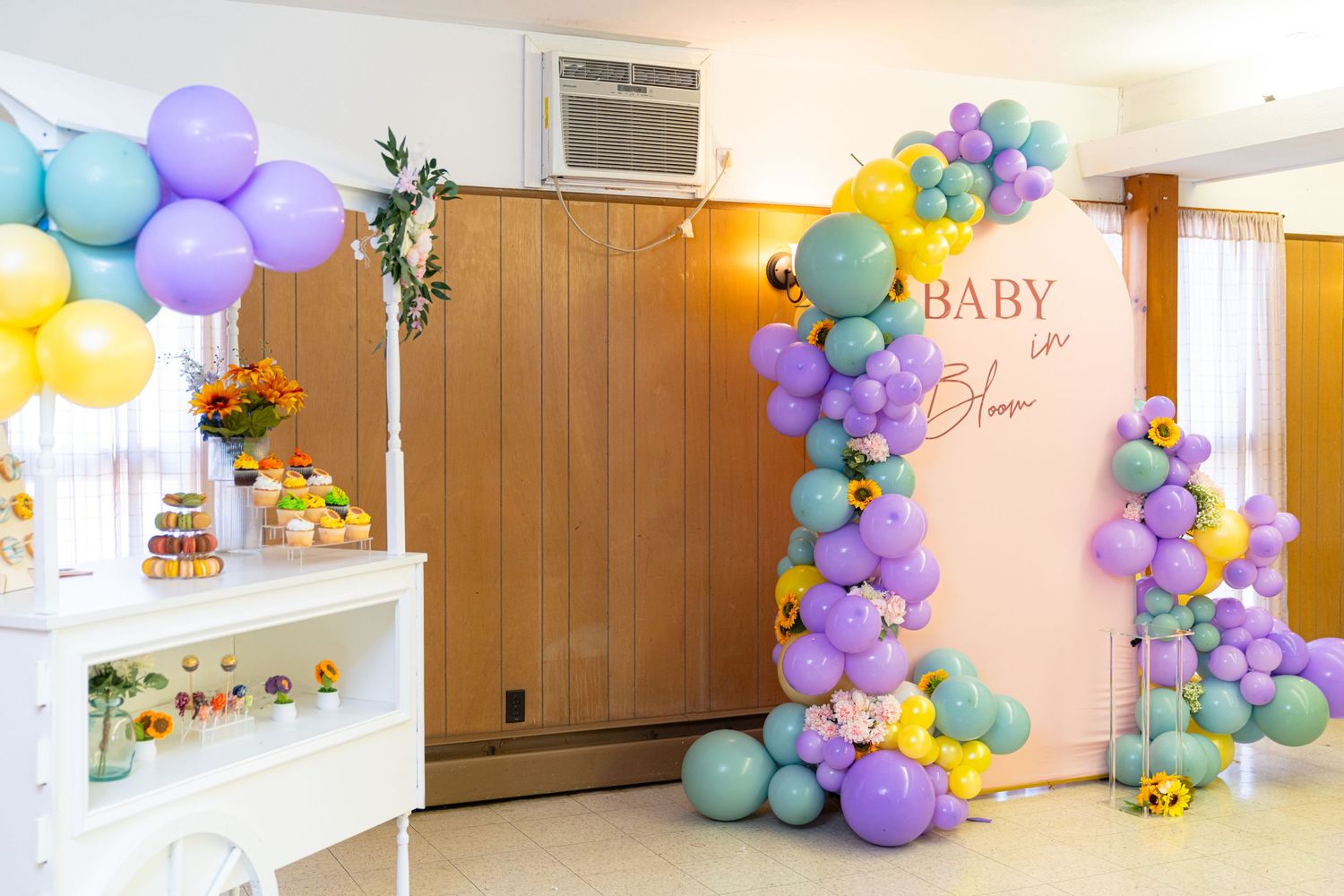 Pastel balloon garland decorating a hallway for a baby celebration.