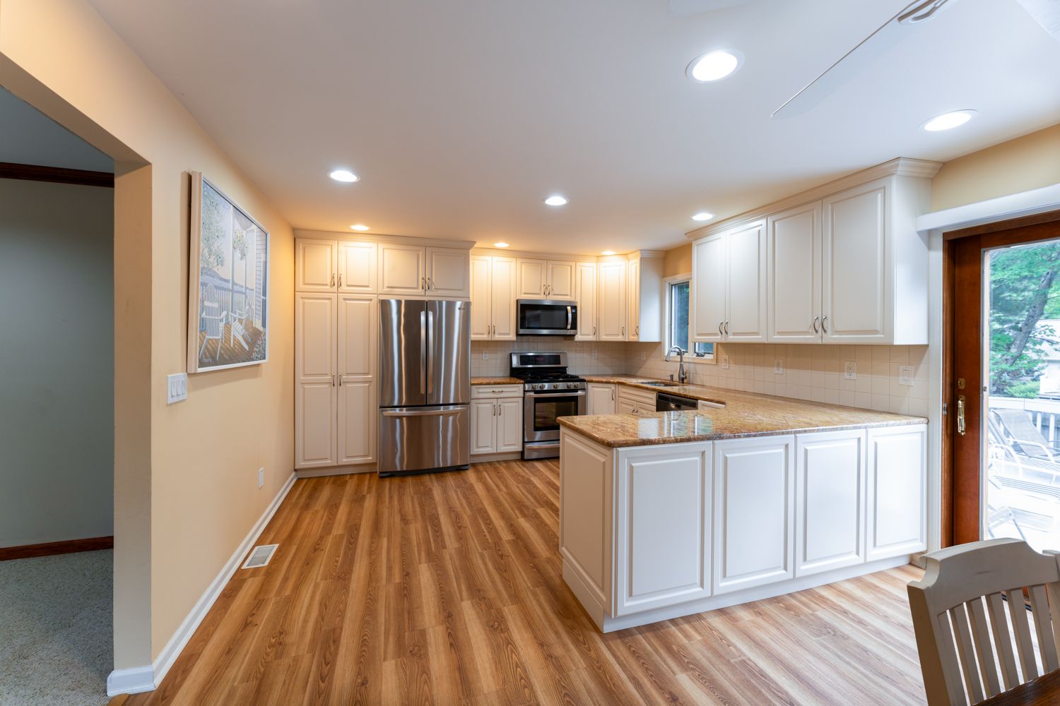 Modern hallway with recessed lighting features light gray walls and a white ceiling spanning down a well-lit corridor.