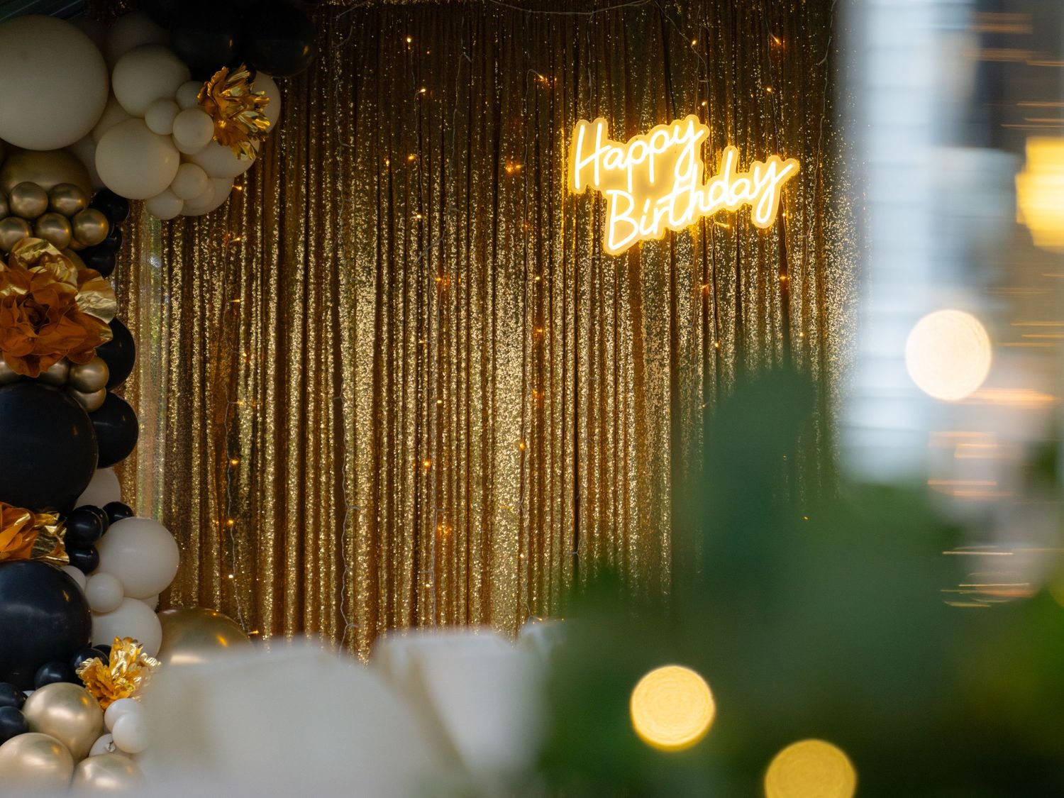 Event space decorated with gold sequin curtains and ambient lighting.