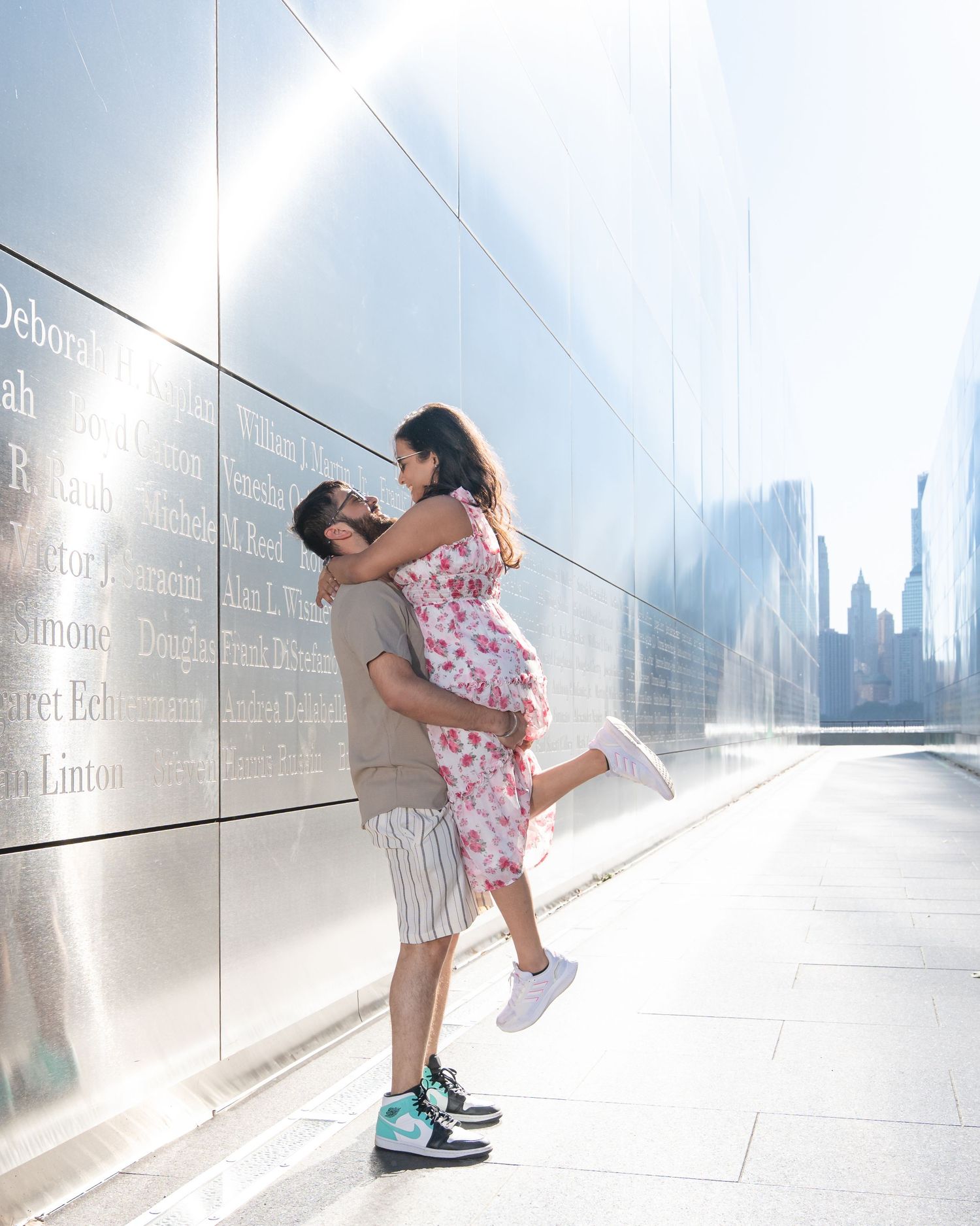 Couple sharing a romantic moment in a bright urban corridor with metallic walls.