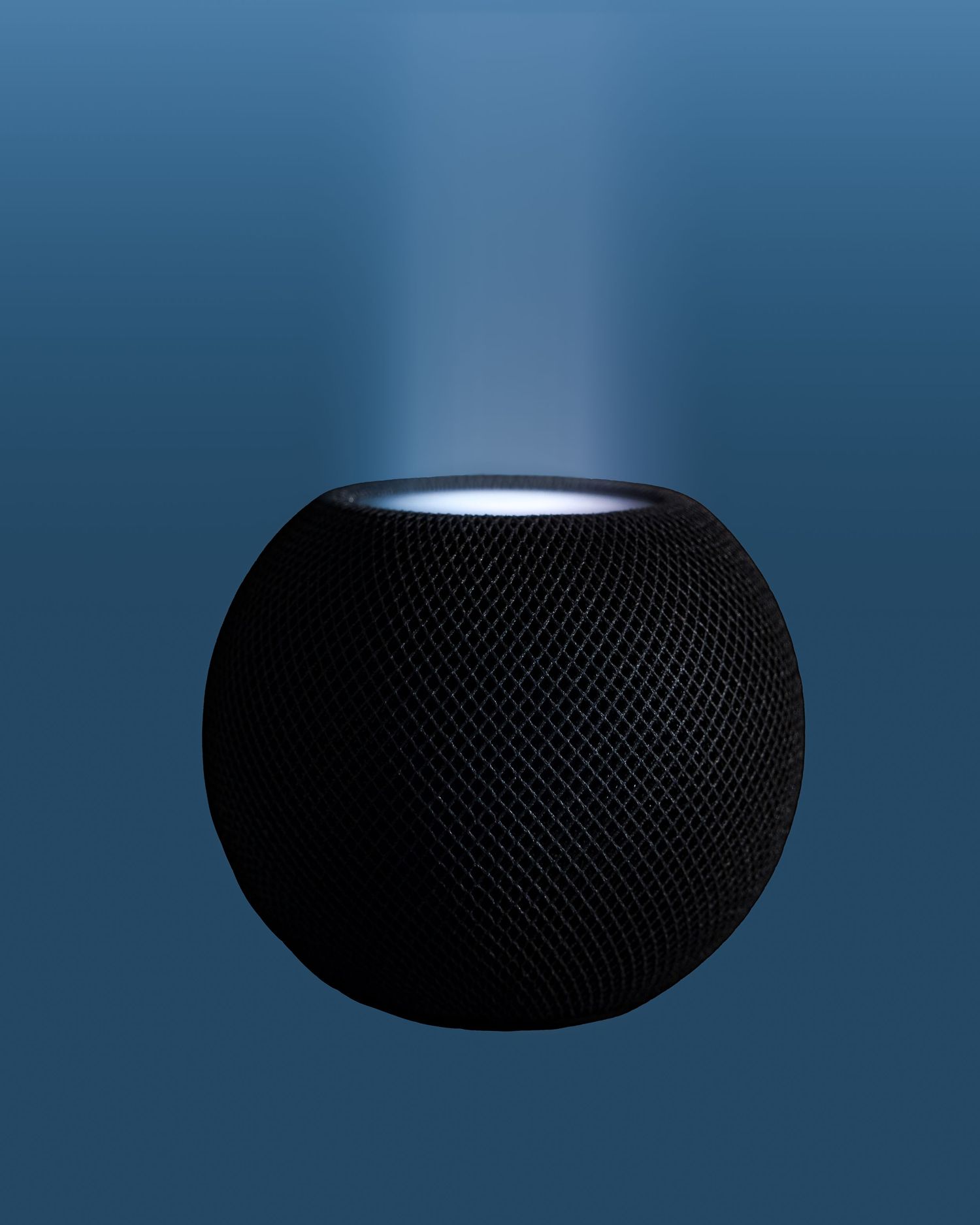 Apple HomePod Mini in black shown in silhouette against a blue gradient background.