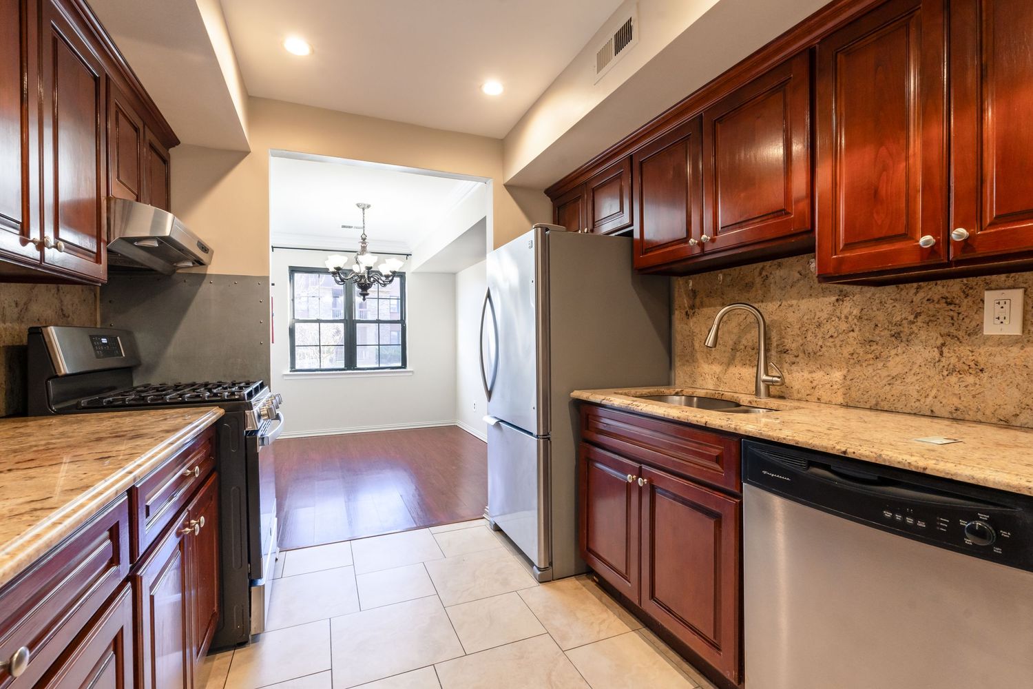 Modern kitchen interior with dark wood cabinets, granite countertops, and stainless steel appliances shown from multiple angles.