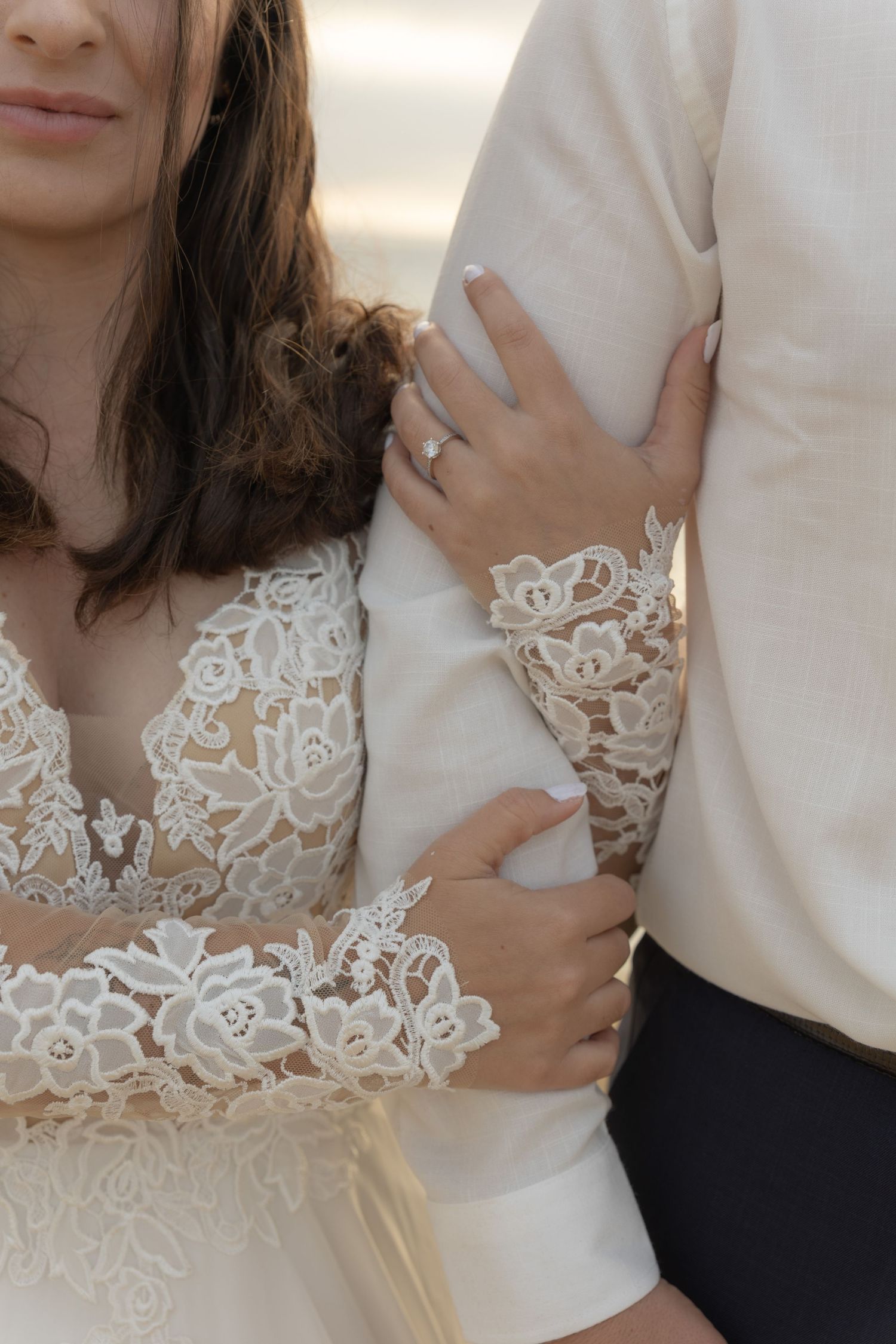Close-up detail shots of delicate white lace appliques on a wedding dress sleeve and neckline.