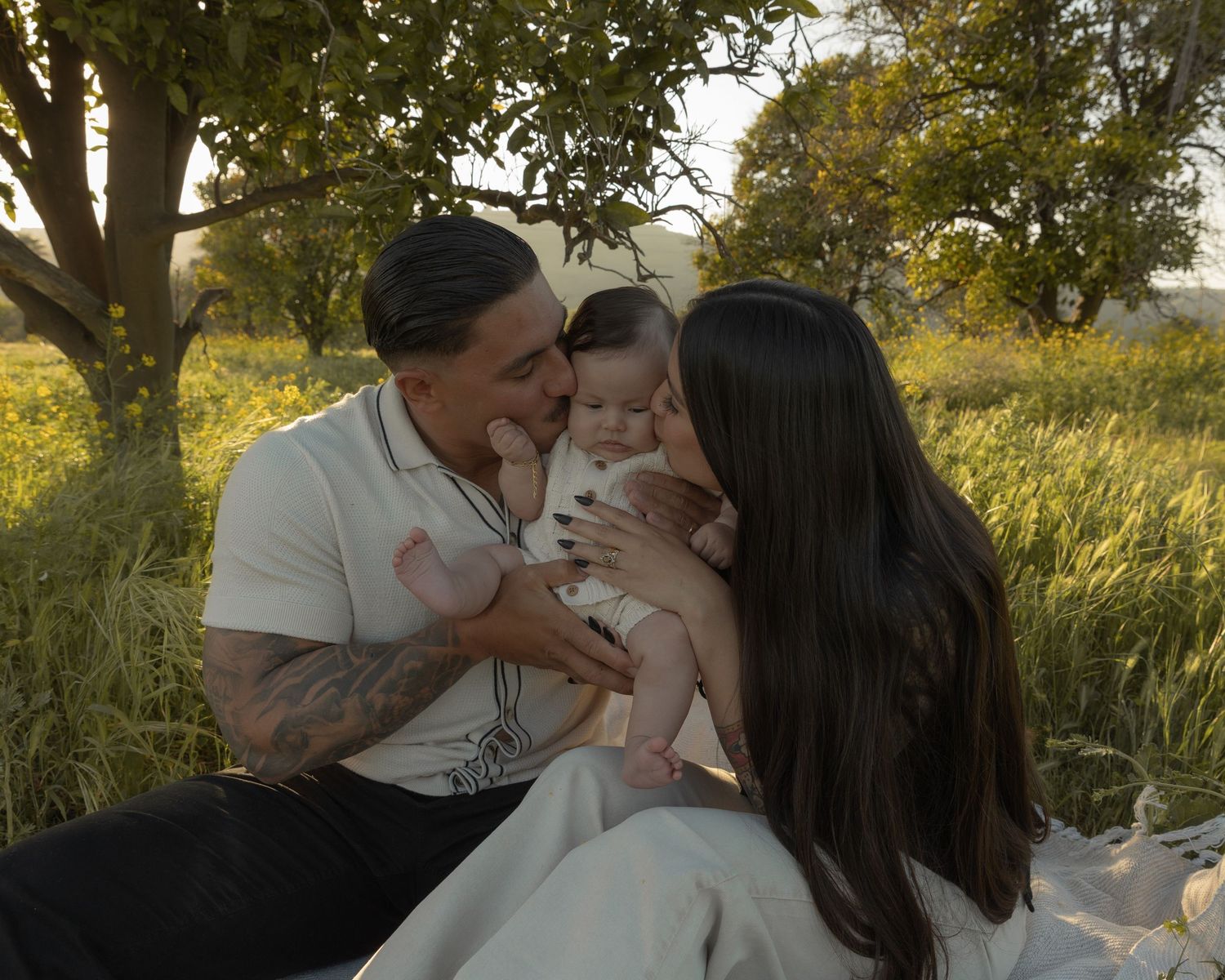 A tender family moment captured under autumn trees at sunset.