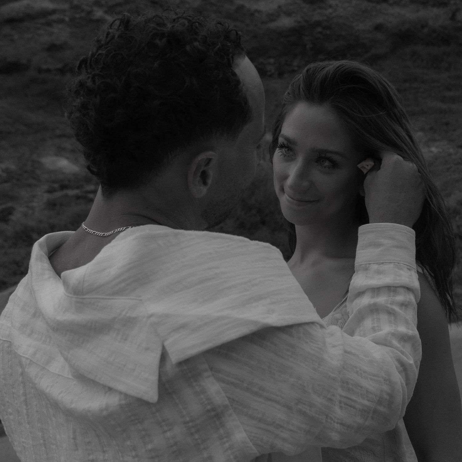 An intimate black and white portrait of two people in white clothing.