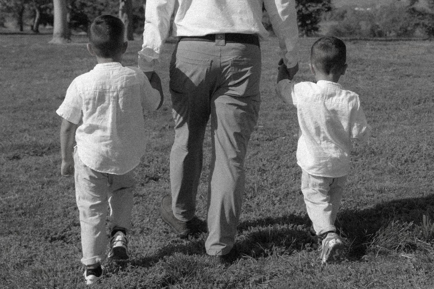People in white clothing walking together across a grassy field.