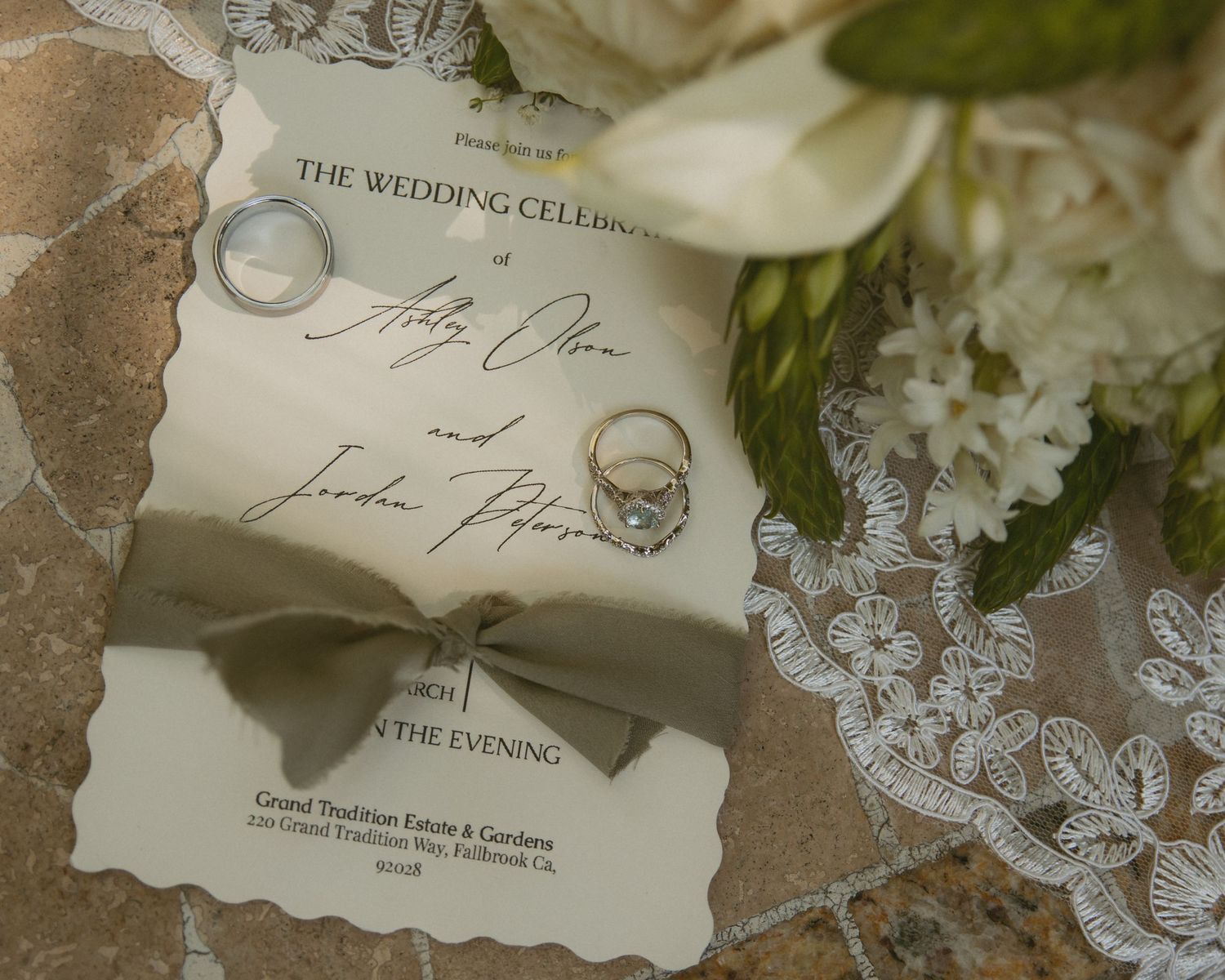 Elegant wedding invitation with rings and floral bouquet for Holly and Jordan's celebration at Grand Tradition Estate.