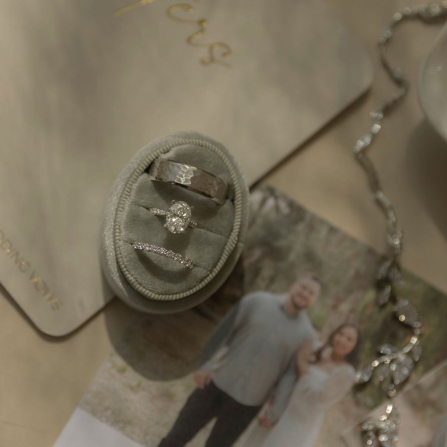 Engagement ring sparkles in a close-up shot against a blurred beige background.