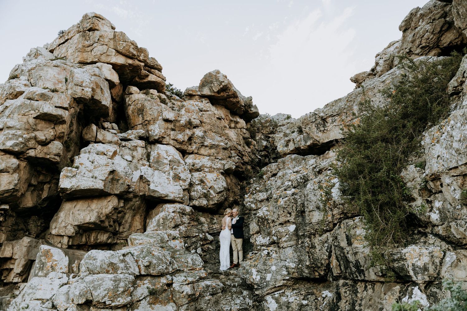 A scenic rocky mountain cliff formation with rugged stone walls and natural weathered textures in warm lighting.
