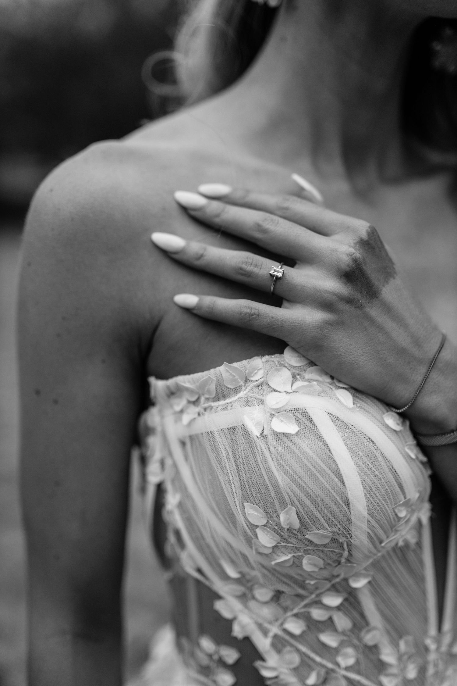 A vintage black and white image showing delicate beading details along the neckline of a wedding dress.