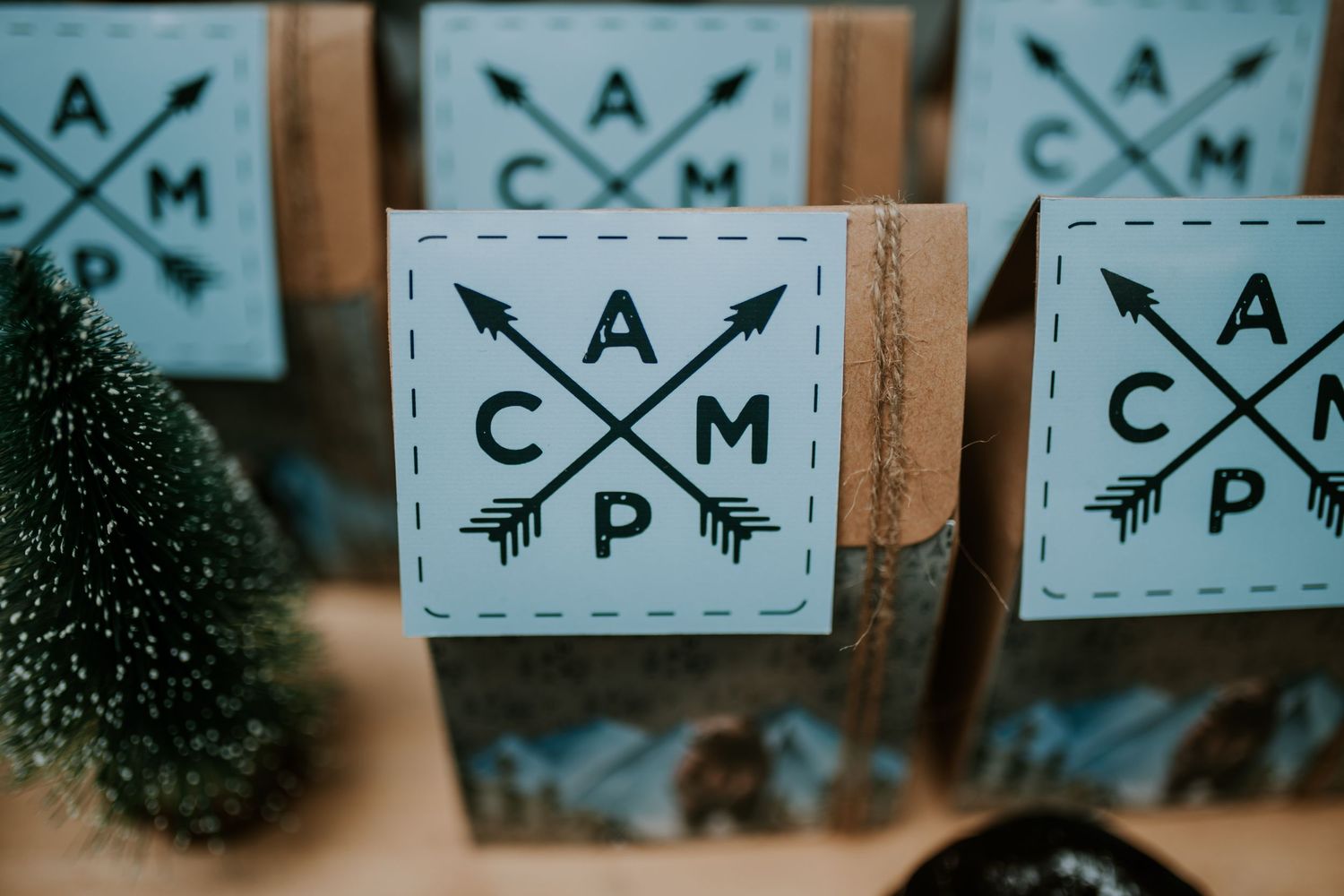 Close-up view of hipster style geometric logo designs with crossed arrows and letters CAMP printed on white boxes.