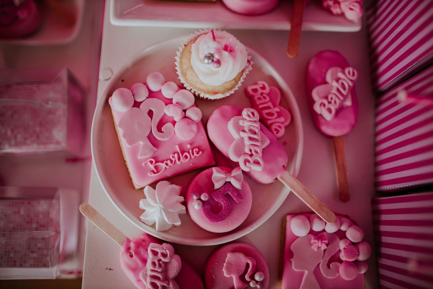 Pink and white Valentine's Day themed cupcakes decorated with hearts and floral designs on a dessert stand.