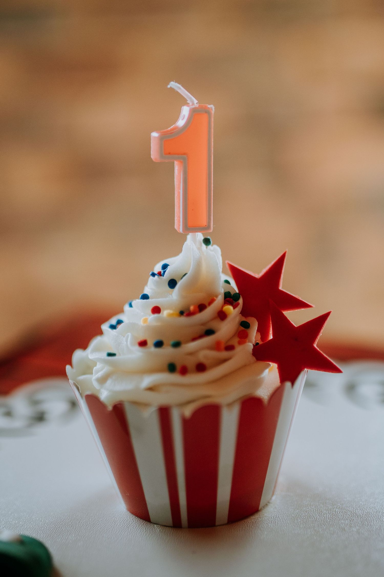 Red and white striped cupcake with vanilla frosting and small red star on top shown in five sequential views.