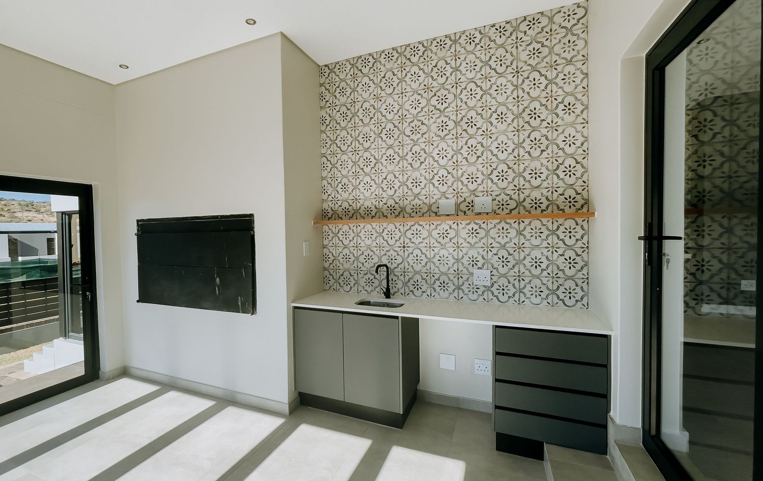 A modern residential interior with wallpapered accent walls and sleek black cabinetry creates a contemporary living space.