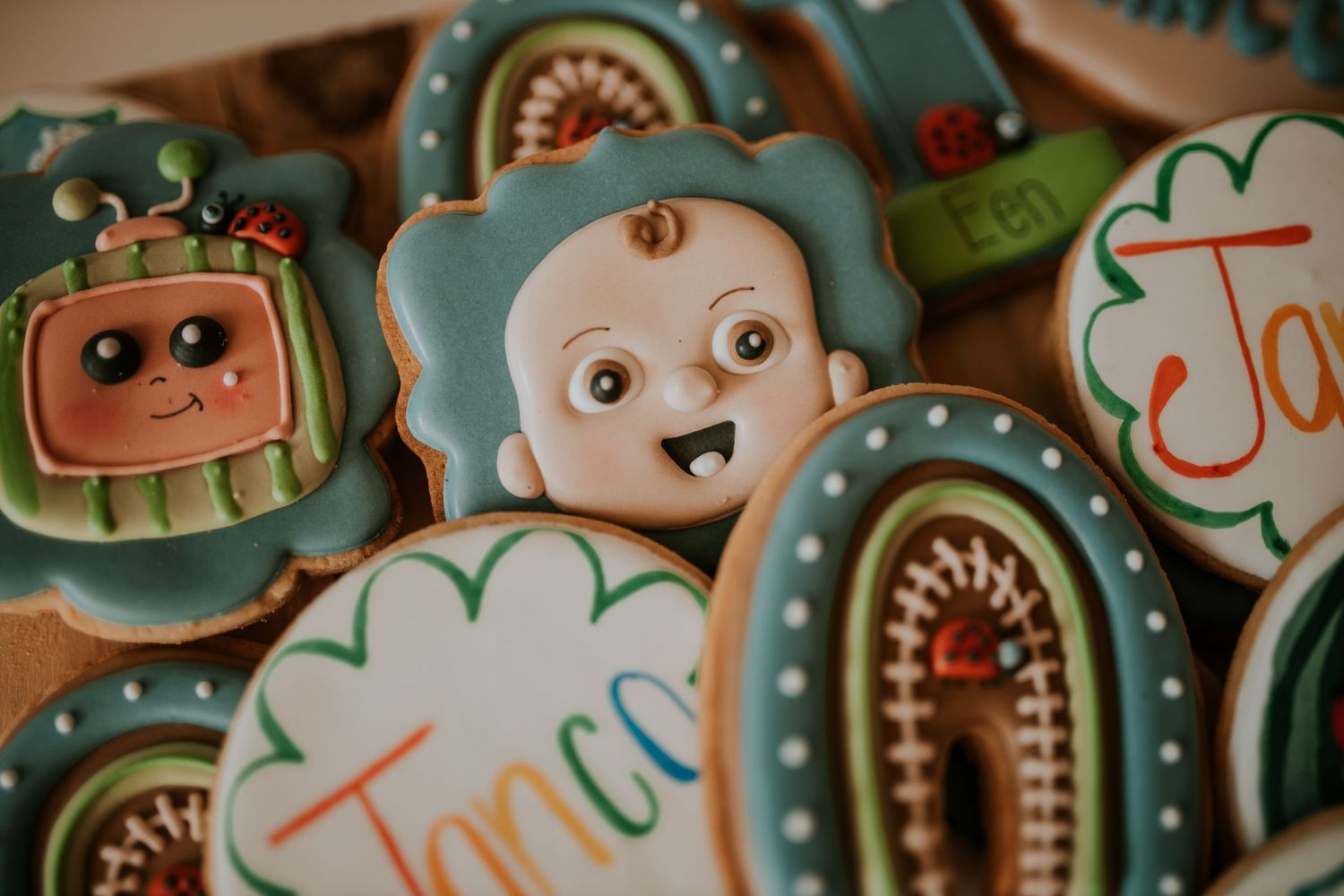 Colorful cartoon monster themed sugar cookies decorated with royal icing and fondant details on a blue background.