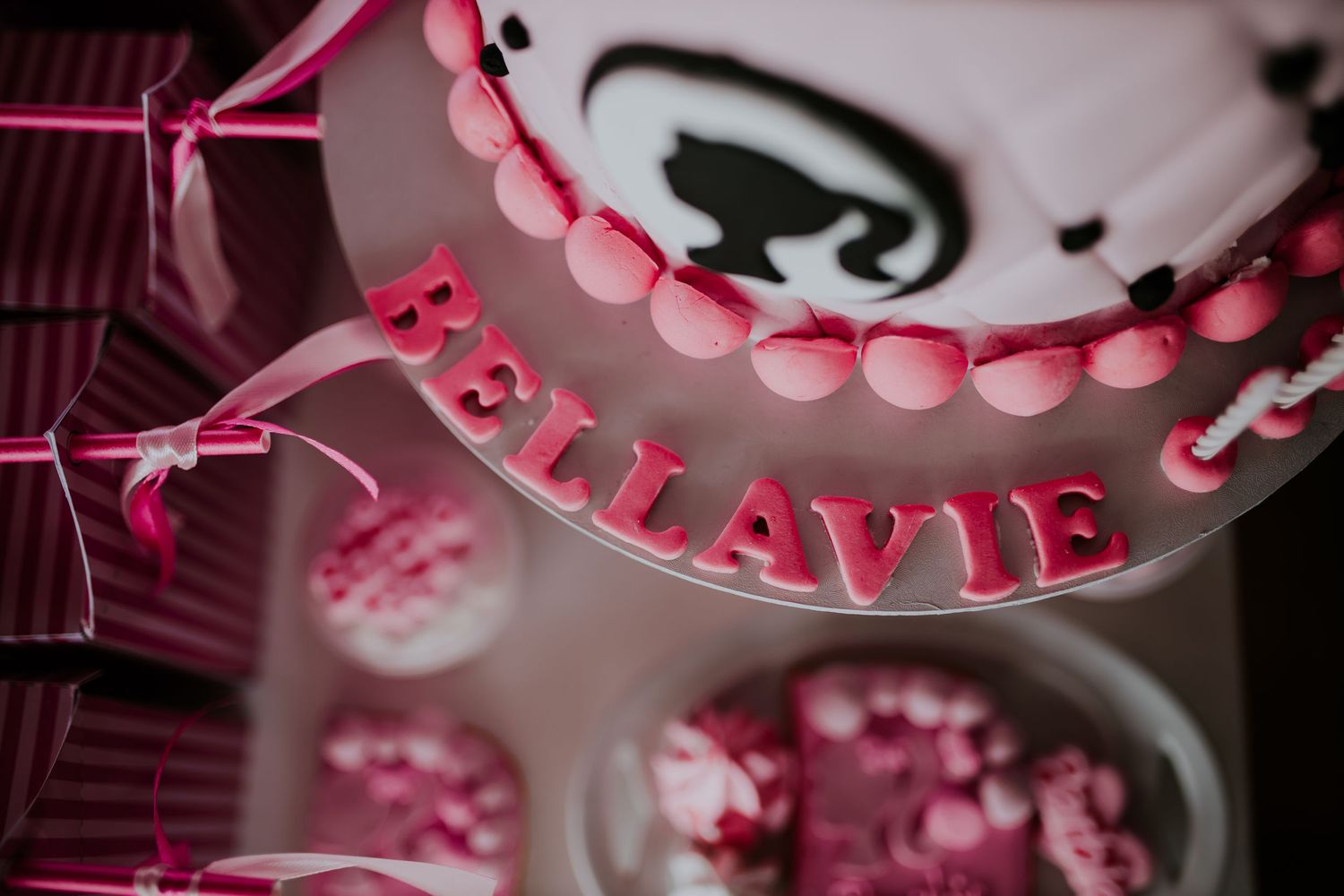 Pink and white layered party decorations with a butterfly theme feature pearl-like beads and delicate ribbons.