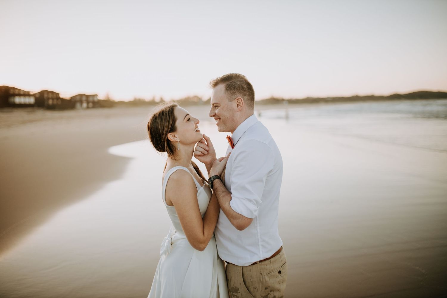 A romantic couple shares a tender moment at sunset on a peaceful beach.