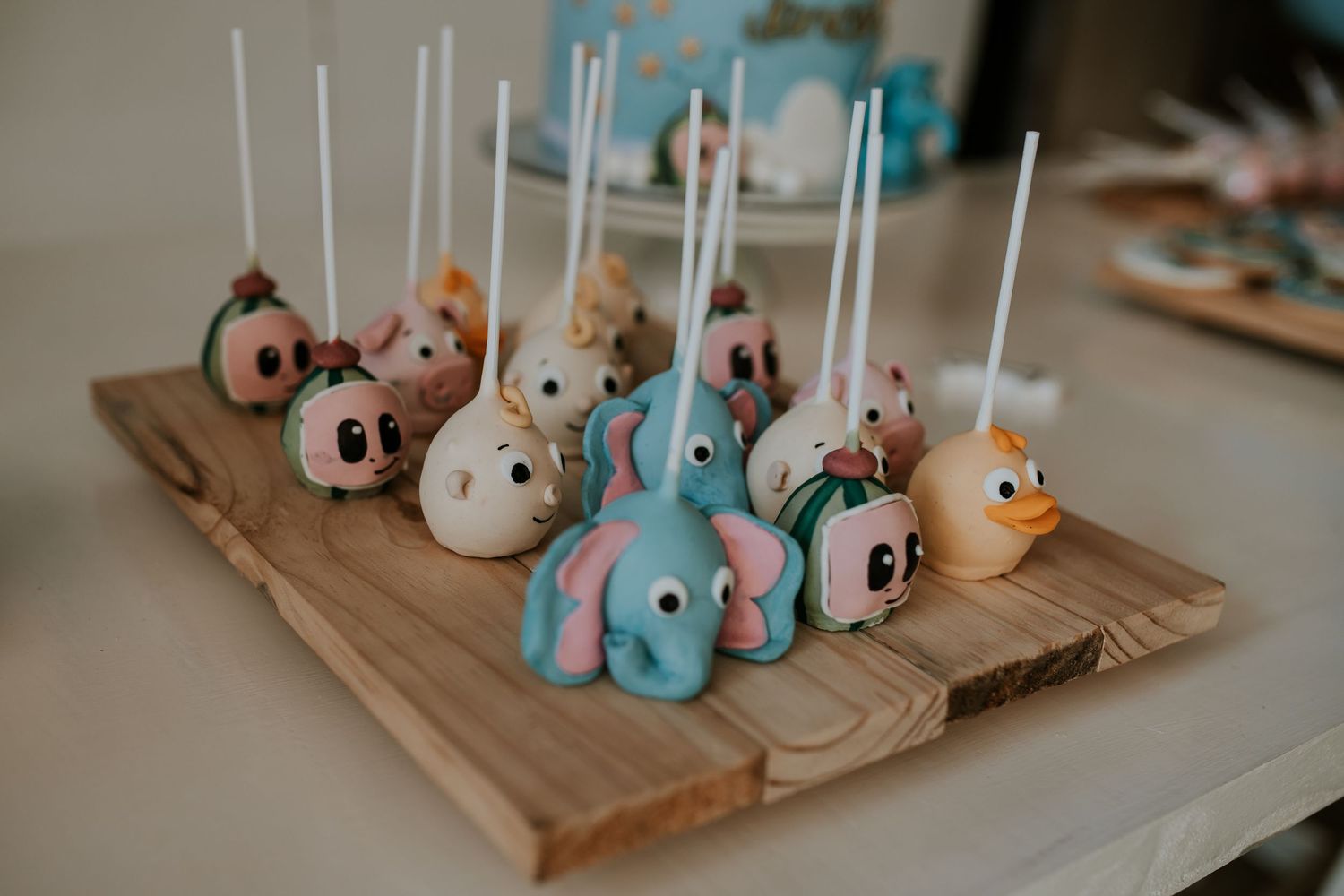 Small ceramic animal figurines displayed on wooden trays in pastel colors create a charming decorative arrangement.