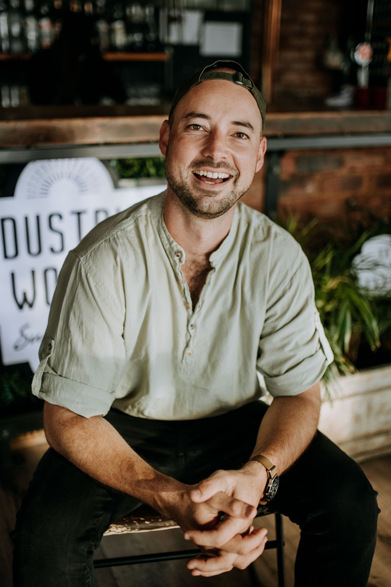 A person wearing a light colored shirt sits casually against a dark background in a progressive series of shots.