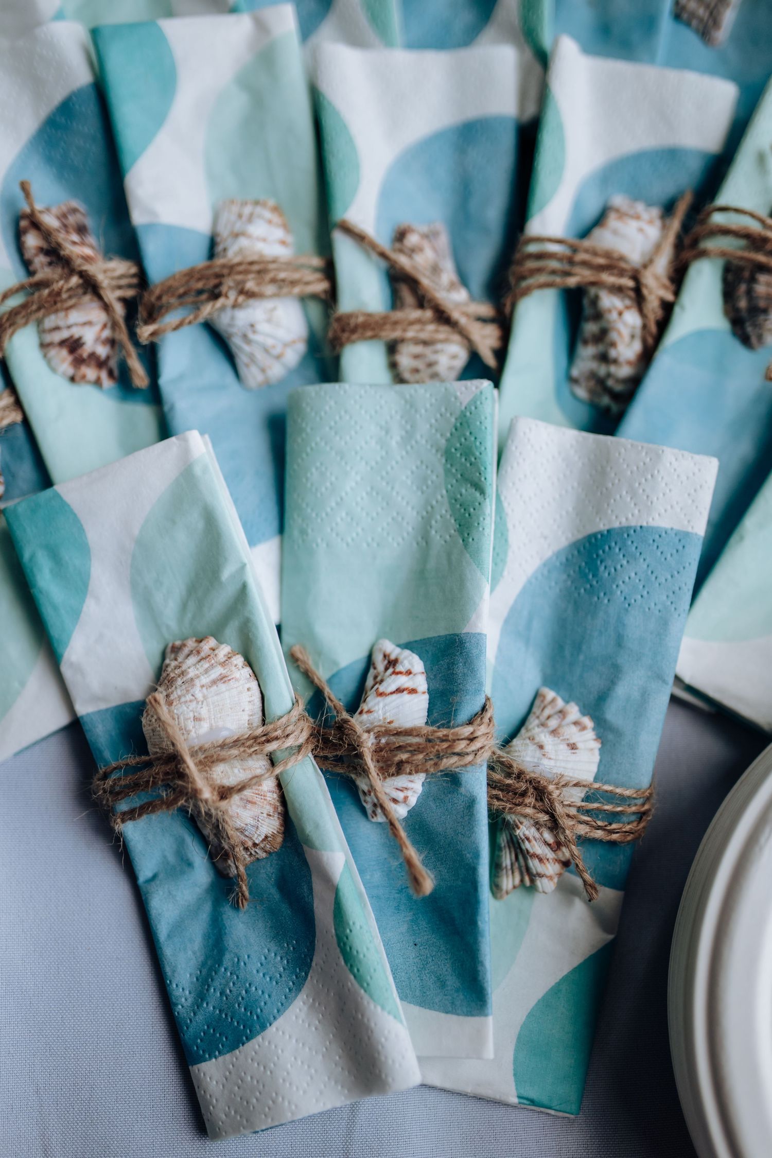 Light blue napkins tied with twine are arranged in rows for an elegant table setting display.
