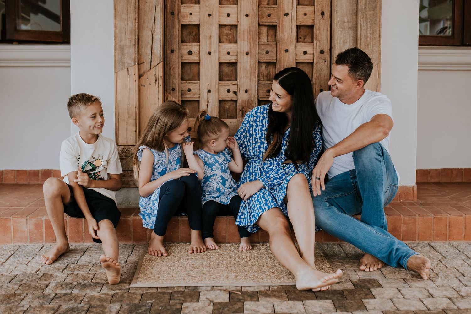 Collage of candid family moments on a hardwood floor showing laughter, embraces, and playful interaction.