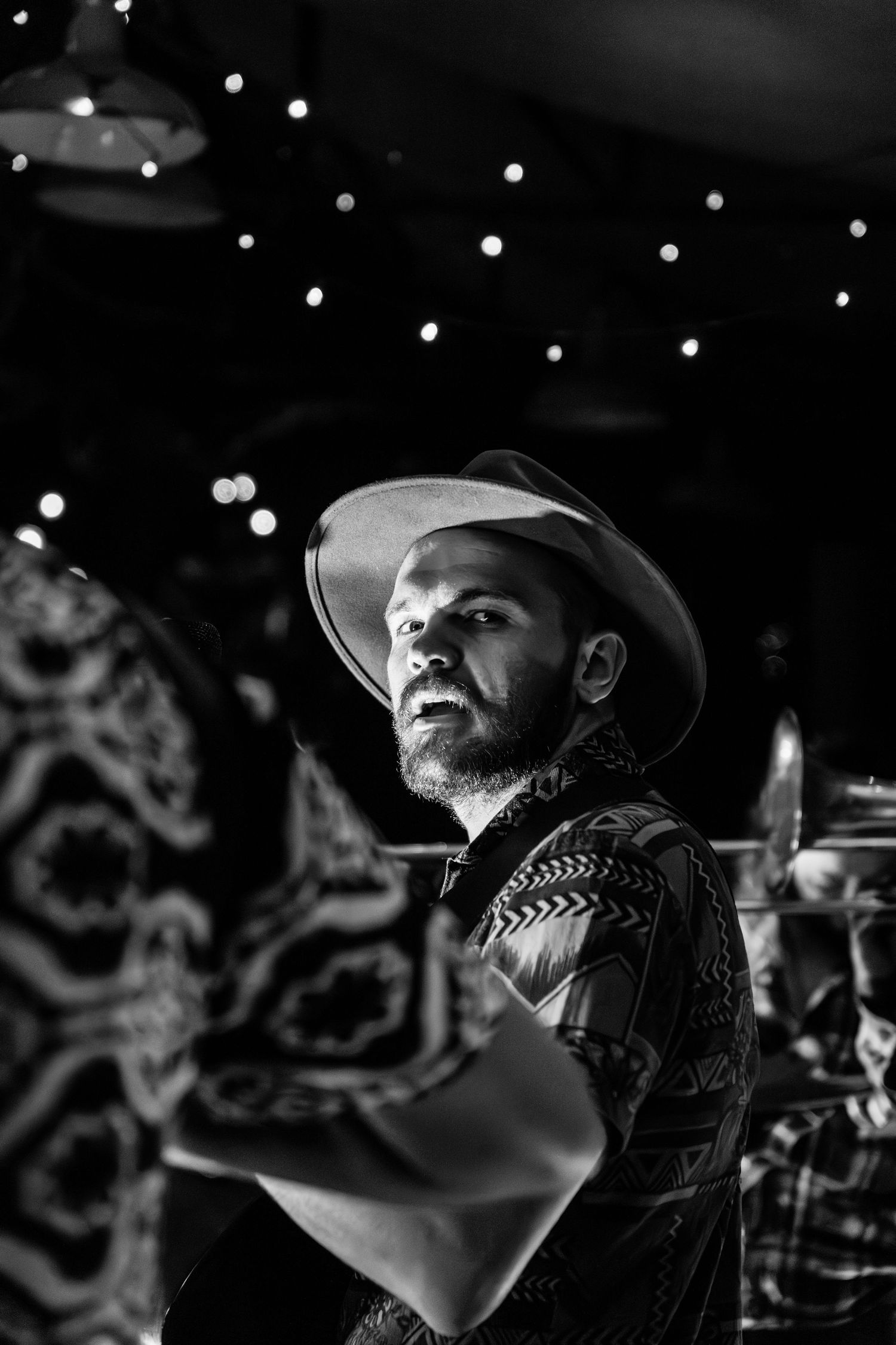 Series of black and white photos showing person with beard looking up at stage lighting during performance.