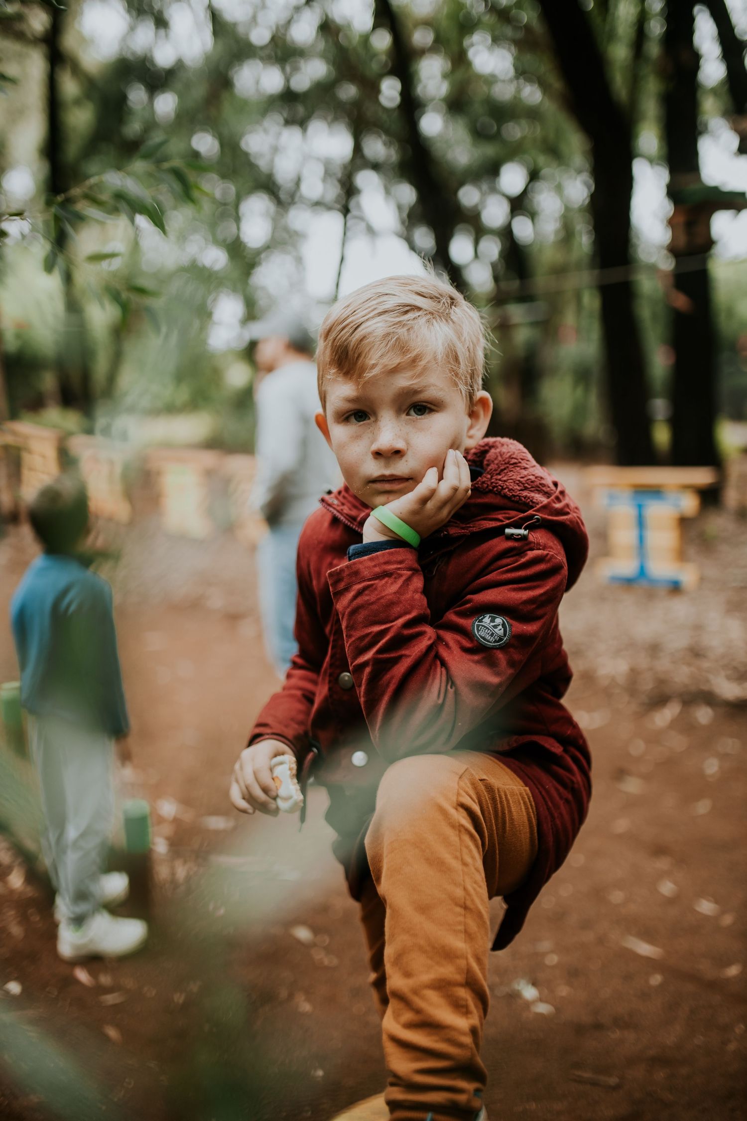 Series of motion shots capturing a child running and playing outdoors in brown pants and a maroon jacket.
