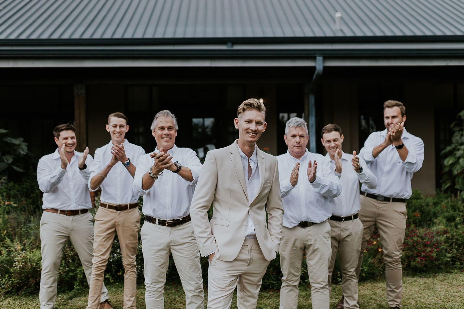A series of wedding photos showing groomsmen posing together in khaki and white attire at an outdoor venue.
