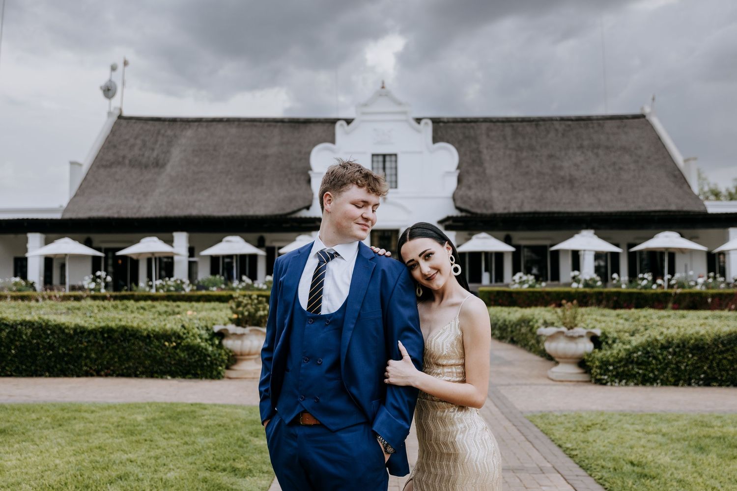 A couple shares a tender moment outside a rustic barn venue during their wedding celebration.