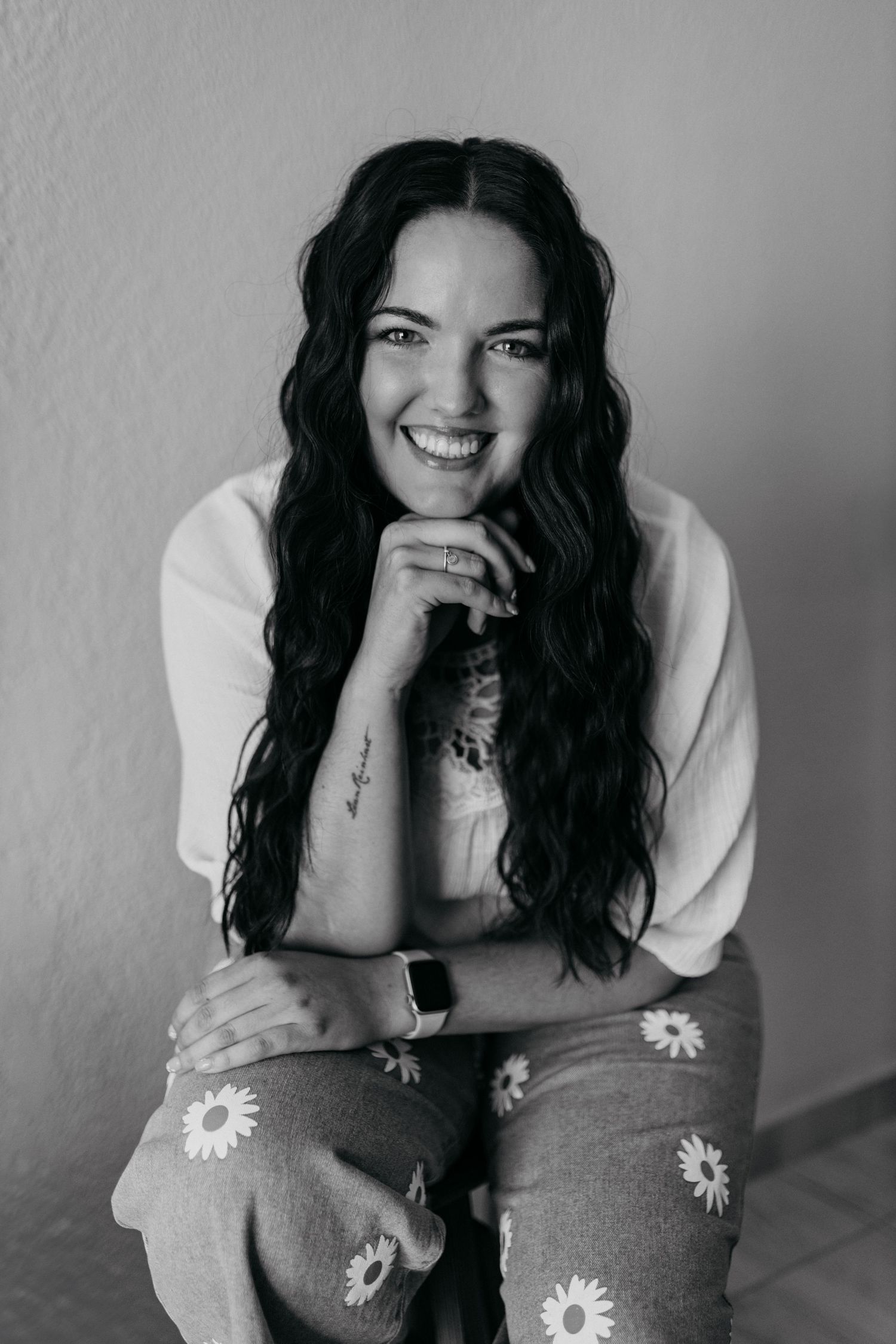 A black and white portrait featuring daisy-patterned pants and casual style.