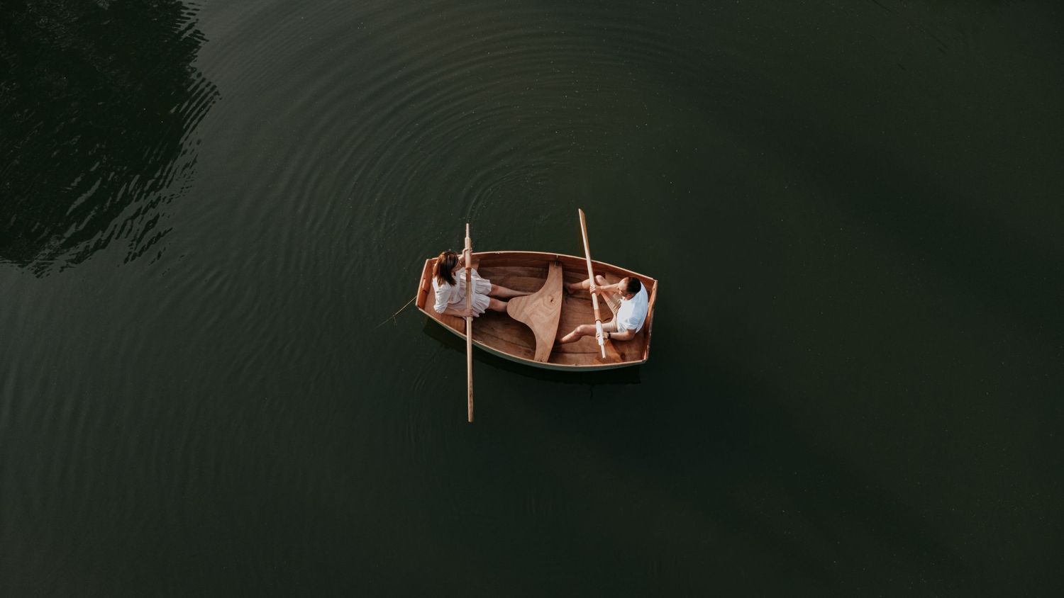 Five aerial views of a lake with scattered docks and boats under different lighting conditions and times of day.