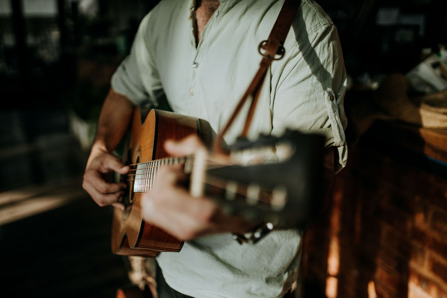 Musicians play acoustic folk instruments during an intimate performance in a dimly lit space.