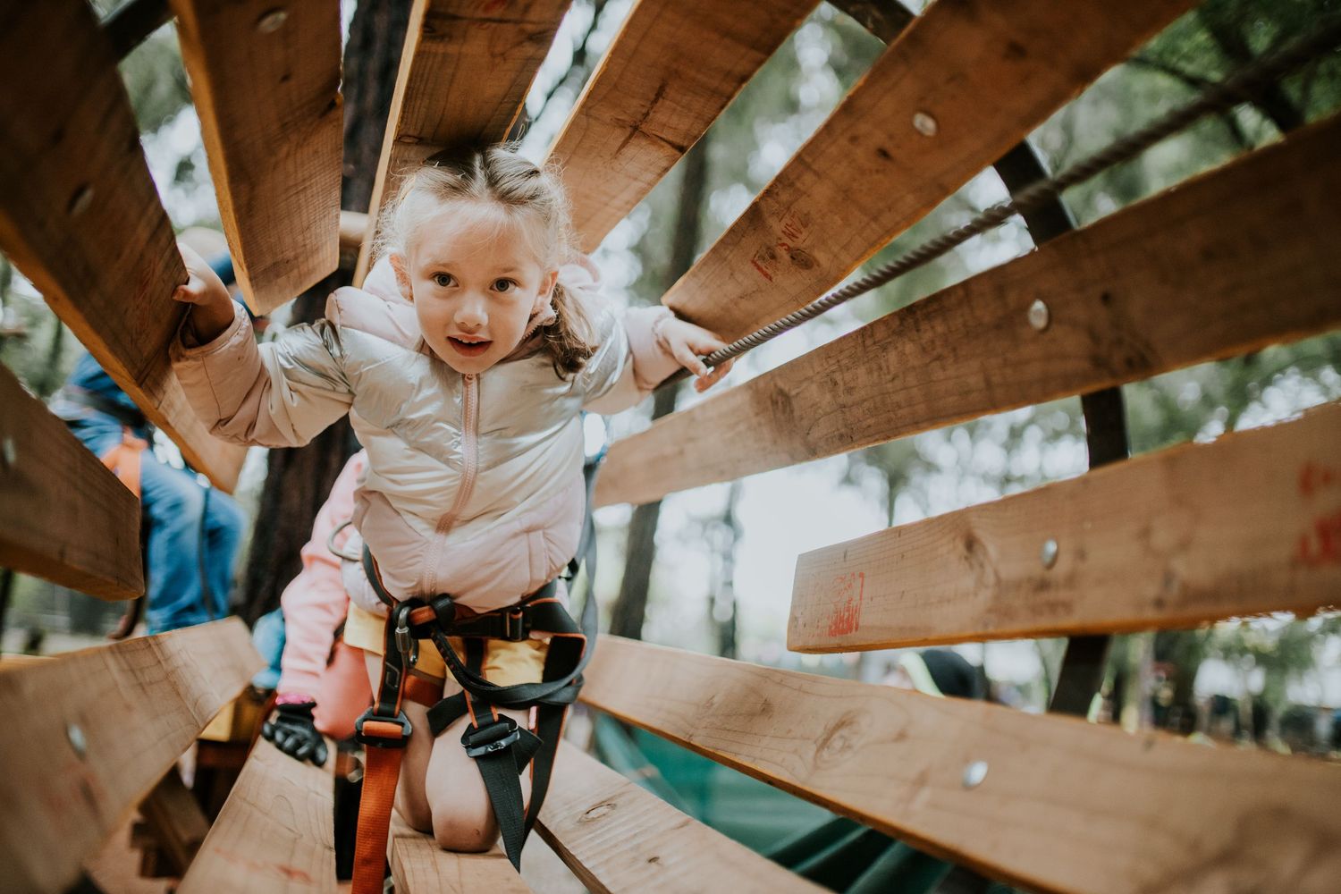 Rock climbing enthusiast scales an indoor climbing wall wearing safety harness and equipment at a training facility.